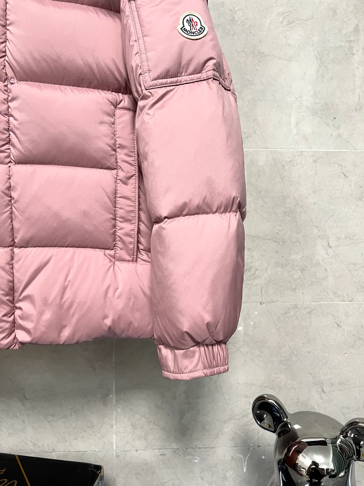 P800 Moncler matte Maya short down jacket. This short parka down jacket is made of longueSaion fabric. The garment is full of functional details to ensure warmth and care. Features removable hood, zip pockets, adjustable cuffs, and snap-zip flap fly. Logo embellished sleeves. It adds a unique touch to the overall shape and significantly improves the protective performance. Color: Black White Pink Pearl White Size: 12345