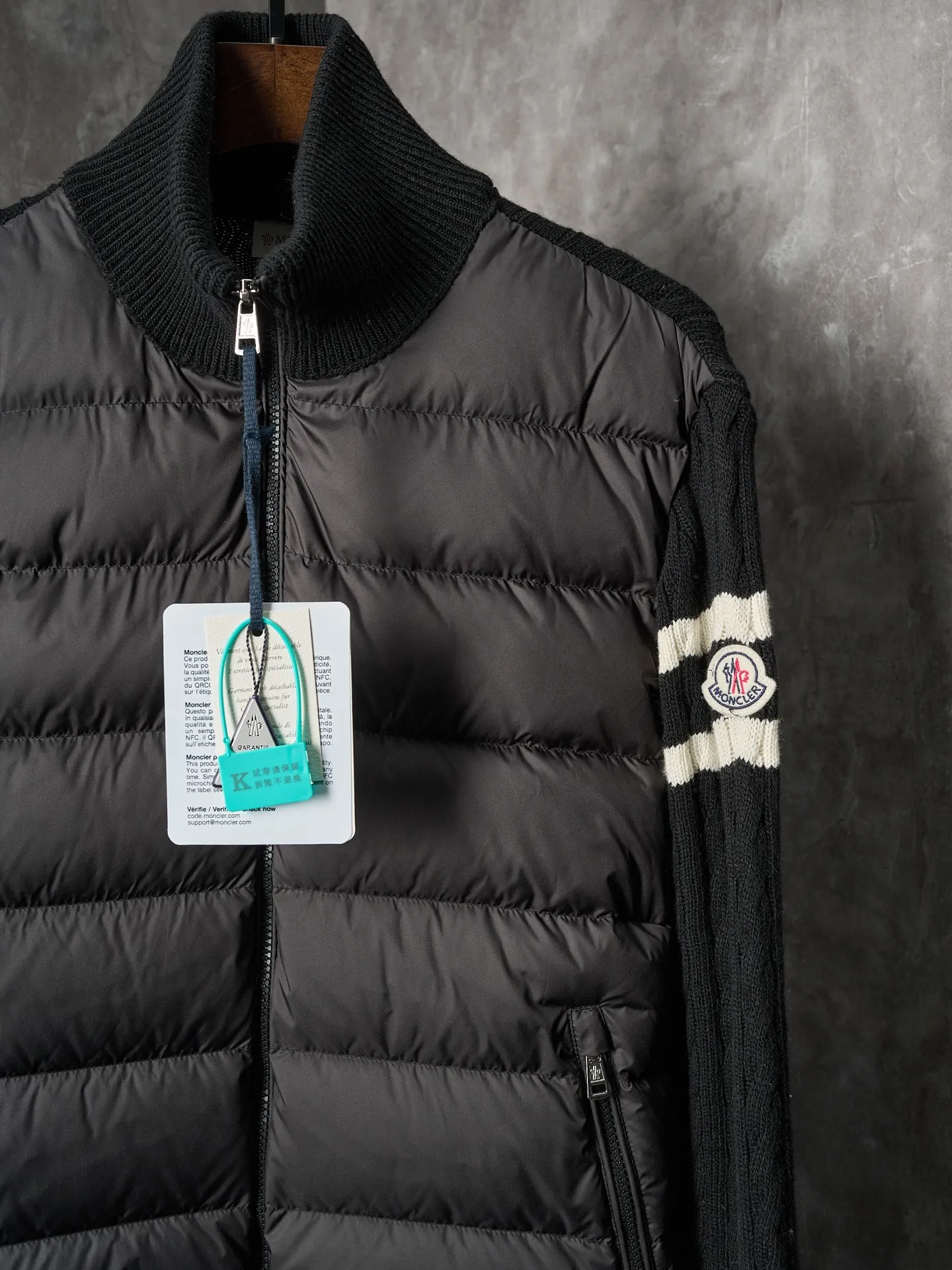 P780 Actual auction] Moncler/Mask Black classic stand-up collar spliced ​​wool knitted parallel bars armband zipper down jacket [Ready stock] S/1 M/2 L/3 XL/4 The outer front fabric is made of 100% nylon (nylon). Its high-density structure achieves excellent windproof effect. It also has strong wear resistance and wrinkle resistance. It is scratch-free for daily wear and easy to take care of.  The splicing design of sweaters and down jackets not only retains the thermal performance of down jackets, but also incorporates the fashion elements of sweaters, making the overall garment both practical and fashionable.  High-quality material: filled with high-quality white duck down, with a filling capacity of 100g, which has excellent thermal insulation effect. At the same time, the sweater is made of wool, cashmere and other natural fibers, which are soft, comfortable and skin-friendly.  The sweaters and down jackets are carefully spliced ​​to ensure comfortable wearing and are not prone to threading or velvet loss.  High collar design: not only provides excellent thermal insulation effect, but also adds a unique sense of fashion, allowing the wearer to maintain style in the cold season.  Stripe decoration: The stripes on the sleeve arms are like bright brush strokes, embellished on the dark gray down jacket, injecting vitality and movement into the overall look, making the clothing more eye-catching.