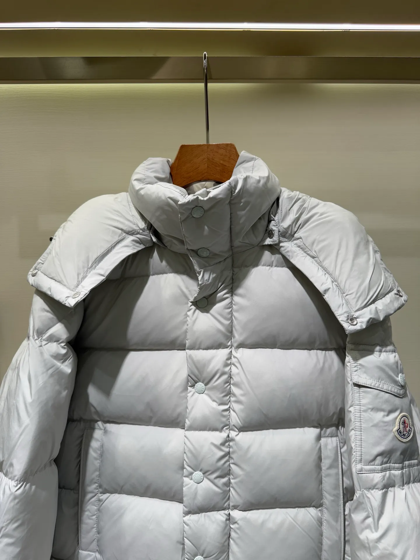 P1080 Moncler Maya Meng Maya Pearl Gray and White Short Down Jacket The Moncler Maya down jacket is made of matte nylon with iconic rectangular quilting, which is a model of Moncler style. A classic cropped design that transcends seasons and styles, it features a statement silhouette, removable hood and adjustable hem. The sleeves are embellished with classic patch pockets, showcasing the brand's signature style.  Fabric: 100% nylon, 90% white duck down Craftsmanship: Made of matte nylon, lacquered nylon lining filled with down, rectangular quilting, detachable hood with snap buttons that can be adjusted by drawstring, two-way zip fly, external and internal zipper pockets, adjustable elastic cuffs with snap buttons, hood with drawstring, sleeves with flap patch pockets, sleeves decorated with Moncler felt trademark. (Supports NFC function) Size: 01234 3543050