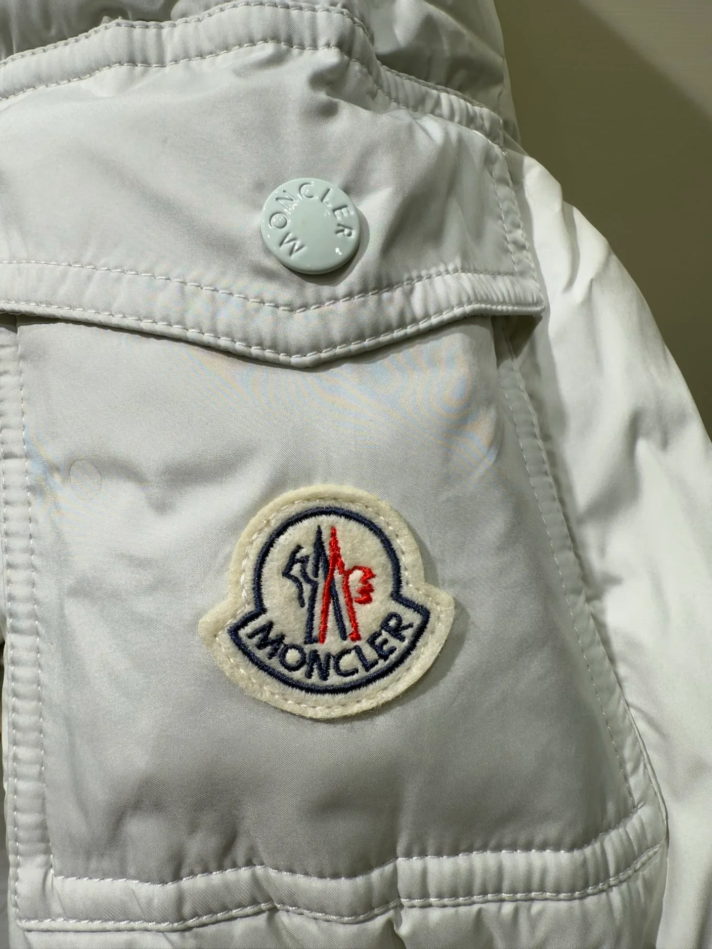 P1080 Moncler Maya Meng Maya Pearl Gray and White Short Down Jacket The Moncler Maya down jacket is made of matte nylon with iconic rectangular quilting, which is a model of Moncler style. A classic cropped design that transcends seasons and styles, it features a statement silhouette, removable hood and adjustable hem. The sleeves are embellished with classic patch pockets, showcasing the brand's signature style.  Fabric: 100% nylon, 90% white duck down Craftsmanship: Made of matte nylon, lacquered nylon lining filled with down, rectangular quilting, detachable hood with snap buttons that can be adjusted by drawstring, two-way zip fly, external and internal zipper pockets, adjustable elastic cuffs with snap buttons, hood with drawstring, sleeves with flap patch pockets, sleeves decorated with Moncler felt trademark. (Supports NFC function) Size: 01234 3543050