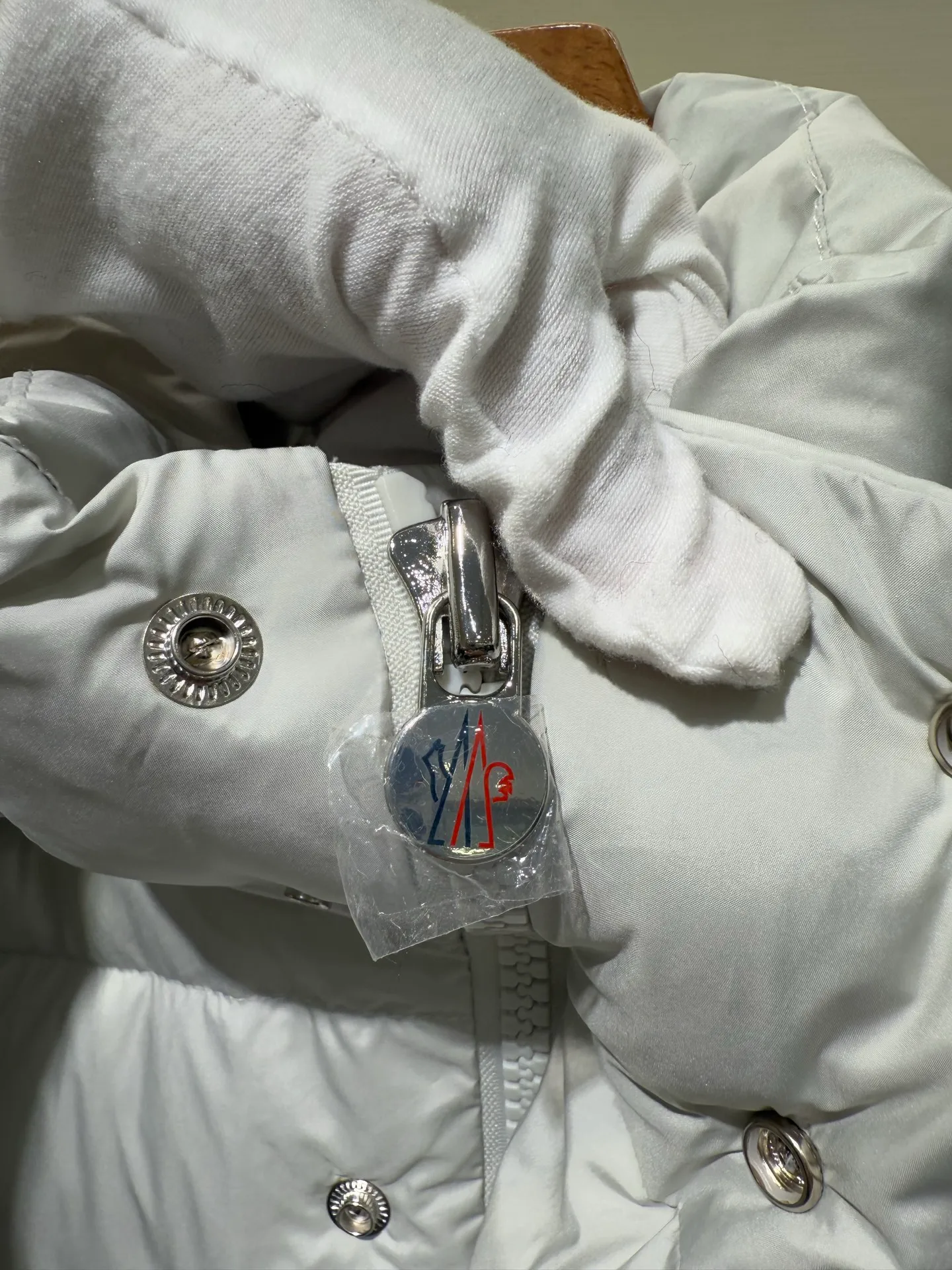 P1080 Moncler Maya Meng Maya Pearl Gray and White Short Down Jacket The Moncler Maya down jacket is made of matte nylon with iconic rectangular quilting, which is a model of Moncler style. A classic cropped design that transcends seasons and styles, it features a statement silhouette, removable hood and adjustable hem. The sleeves are embellished with classic patch pockets, showcasing the brand's signature style.  Fabric: 100% nylon, 90% white duck down Craftsmanship: Made of matte nylon, lacquered nylon lining filled with down, rectangular quilting, detachable hood with snap buttons that can be adjusted by drawstring, two-way zip fly, external and internal zipper pockets, adjustable elastic cuffs with snap buttons, hood with drawstring, sleeves with flap patch pockets, sleeves decorated with Moncler felt trademark. (Supports NFC function) Size: 01234 3543050