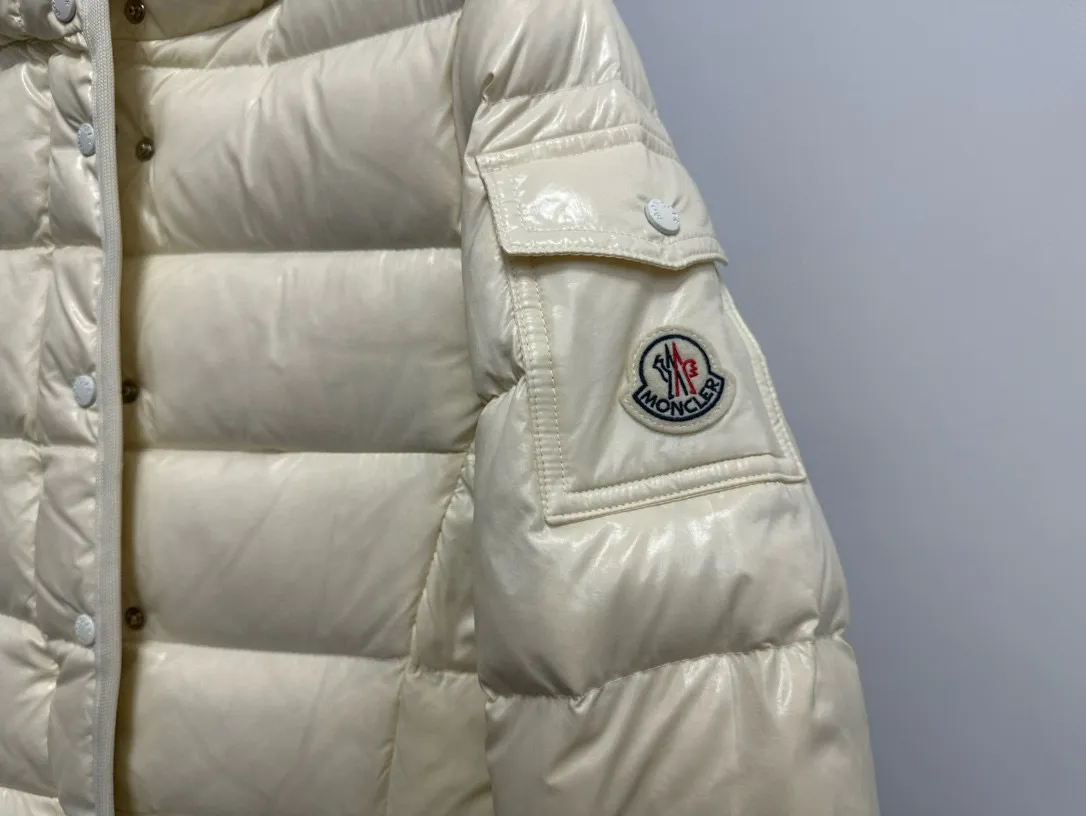 P860 [Moncler] Hooded, waisted women's short down jacket. The barante down jacket is made of glossy nylon fabric and is inspired by the 1970s. It adopts a waist design and presents an A-line silhouette, highlighting a feminine style. An adjustable hood and signature logo patch add finishing touches. Details · Made of lon laqué fabric · lon laqué lining · Filled with down · Adjustable hood · Zipper and snap closure · Suit pocket · Adjustable cuffs Size: 0/1/2/3