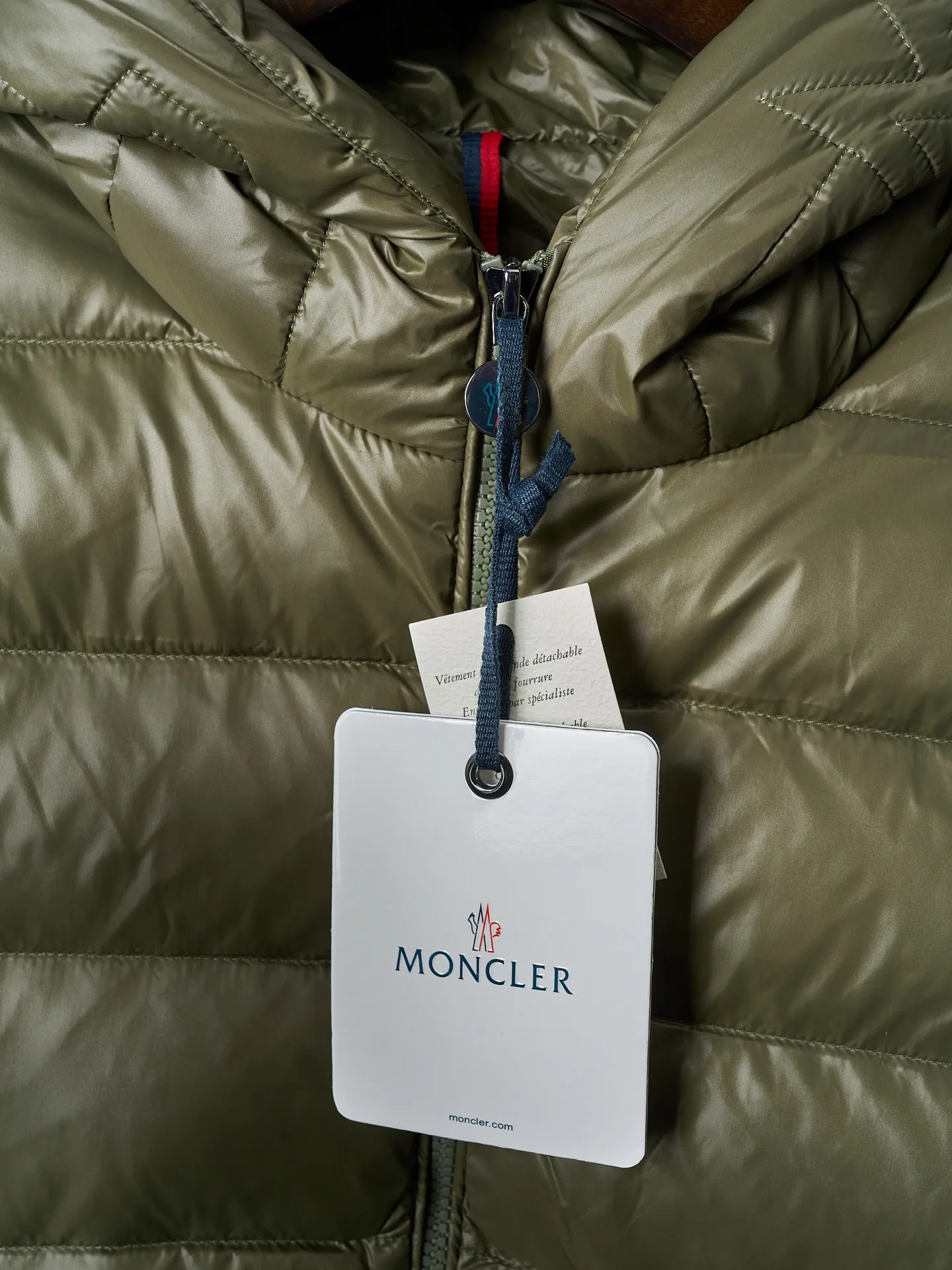 P900 Actual hanging auction] MONCLER/Maskled brim quilted embroidered pocket logo hooded down jacket [Ready stock] 1 2 3 4 Filled with 90 selected white duck down, weighing 210g, ensuring fast fluffy rebound, lightness and warmth.  The longue saison fabric made of high-count polyamide fiber is famous for its excellent tensile strength and lightness. Its good flexibility makes the fabric less prone to wrinkles and keeps it crisp and stylish for a long time. The tight weave effectively blocks the invasion of cold wind and locks in the warm air generated by the down layer. The high-density nylon surface forms a certain lotus leaf effect, making it difficult for small water droplets to penetrate, keeping the interior dry and effectively extending the service life of the down.  The high-density lining is woven with ultra-fine denier, with a thickness of 0.08mm to avoid increasing the overall weight and making it smooth to wear. The high-density woven structure forms a wind resistance layer to protect the thermal efficiency of the thermal layer from loss. It can also withstand the expansion pressure of down and prevent deformation and damage after long-term use.  The quilted letter logo on the brim uses contour quilting technology. The stitches are routed along the edge of the set outline, and the filler is compressed inside the letter graphic, so that the logo is three-dimensional and the pattern is clear.