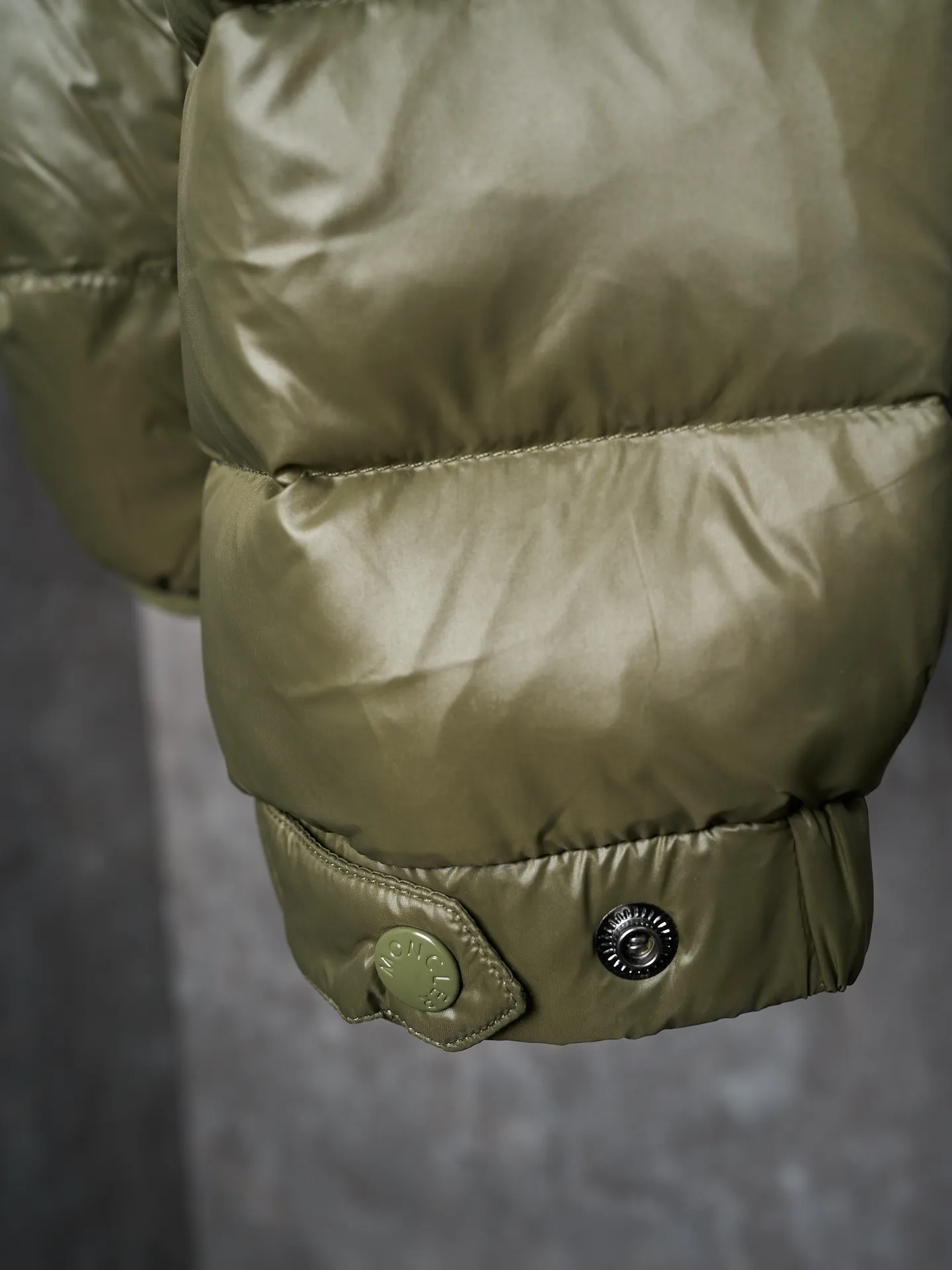 P900 Actual hanging auction] MONCLER/Maskled brim quilted embroidered pocket logo hooded down jacket [Ready stock] 1 2 3 4 Filled with 90 selected white duck down, weighing 210g, ensuring fast fluffy rebound, lightness and warmth.  The longue saison fabric made of high-count polyamide fiber is famous for its excellent tensile strength and lightness. Its good flexibility makes the fabric less prone to wrinkles and keeps it crisp and stylish for a long time. The tight weave effectively blocks the invasion of cold wind and locks in the warm air generated by the down layer. The high-density nylon surface forms a certain lotus leaf effect, making it difficult for small water droplets to penetrate, keeping the interior dry and effectively extending the service life of the down.  The high-density lining is woven with ultra-fine denier, with a thickness of 0.08mm to avoid increasing the overall weight and making it smooth to wear. The high-density woven structure forms a wind resistance layer to protect the thermal efficiency of the thermal layer from loss. It can also withstand the expansion pressure of down and prevent deformation and damage after long-term use.  The quilted letter logo on the brim uses contour quilting technology. The stitches are routed along the edge of the set outline, and the filler is compressed inside the letter graphic, so that the logo is three-dimensional and the pattern is clear.