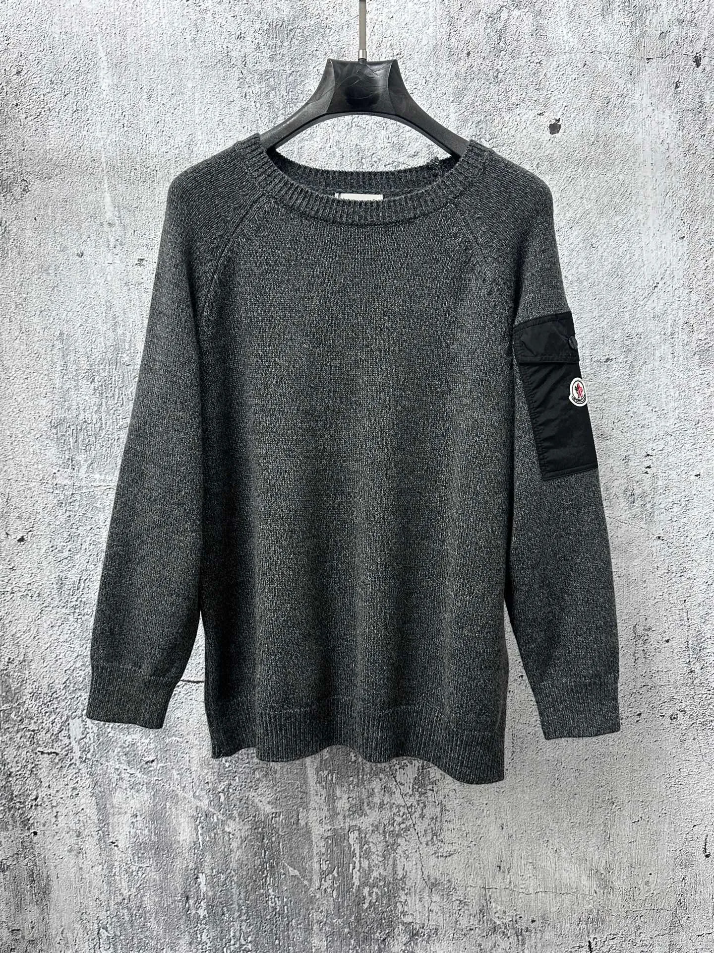 P400 [MONCLER] Mouthless 25FW new sleeve pocket sweater - The fabric is made of wool blended fabric, mainly 90% wool, combined with 10% cashmere. The main body of wool ensures the warmth and comfort of the clothing. The addition of a small amount of nylon and spandex significantly improves the elasticity and wear resistance. -The ribbed decorative parts are made of 100% wool, which further enhances the overall texture. Through the high needle count and fine gauge loom, combined with the orderly direction of the internal yarn, the floating yarn is cleverly woven and stored, with almost no unnecessary thread mess. The nylon pockets on the sleeves are embellished with brand logos, xh is low-key and luxurious. Size: S-XL