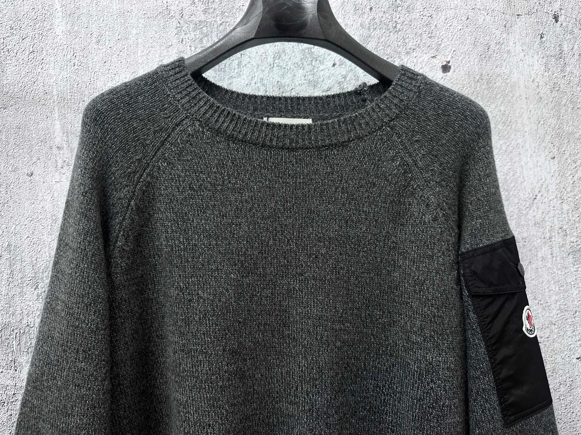 P400 [MONCLER] Mouthless 25FW new sleeve pocket sweater - The fabric is made of wool blended fabric, mainly 90% wool, combined with 10% cashmere. The main body of wool ensures the warmth and comfort of the clothing. The addition of a small amount of nylon and spandex significantly improves the elasticity and wear resistance. -The ribbed decorative parts are made of 100% wool, which further enhances the overall texture. Through the high needle count and fine gauge loom, combined with the orderly direction of the internal yarn, the floating yarn is cleverly woven and stored, with almost no unnecessary thread mess. The nylon pockets on the sleeves are embellished with brand logos, xh is low-key and luxurious. Size: S-XL