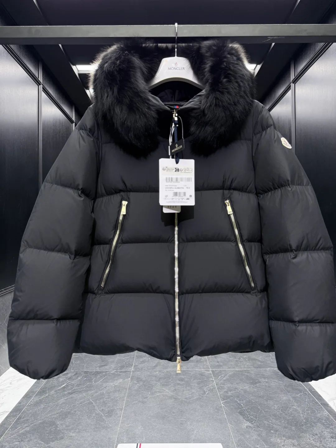 P1040 Premium down ⬆️Moncler Laichefur hooded short down jacket. Duck down filling. Oversized fur collar. Original replacement fabrics ➕Original matching hardware. The tag bar code is complete and consistent with the official website. The tag has built-in NFC electronic sensor anti-counterfeiting. Supports multiple anti-counterfeiting verifications. The Laichefur women's short down jacket is classic and elegant, with a detachable wool collar.  Product Details: The Laichefur Down Jacket is designed to be both feminine and practical for all-day wear. Features a hood in brushed polyester with an elegant matte finish. Paired with a detachable fleece collar, it provides warmth and protection in different environments.  Details: •Made from brushed polyester •Longue saison lining •Down filling •Hood •Removable fleece collar •Zip closure •Zip pockets Size: 1-4 Black/Off White