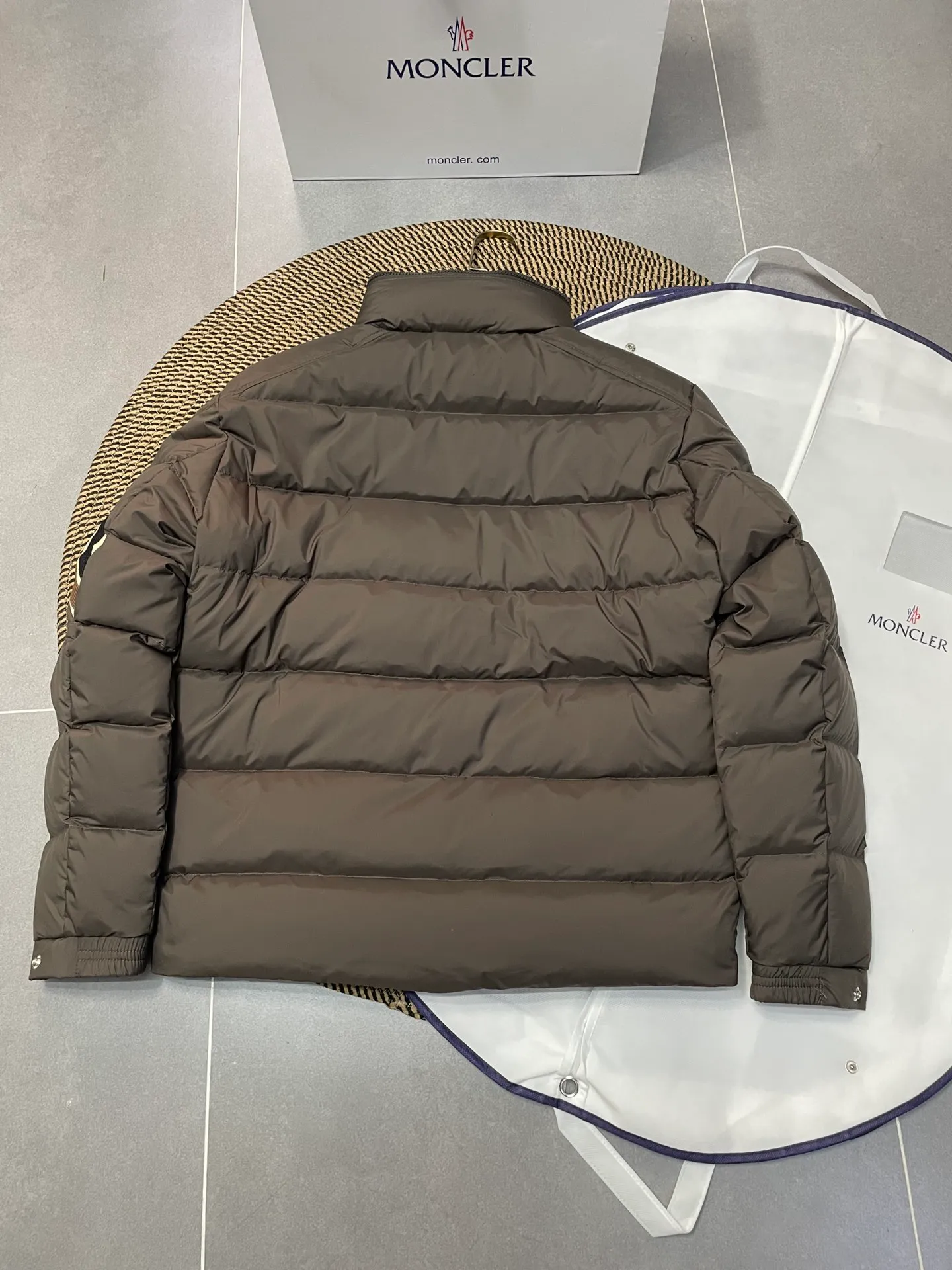 P840 🆕❤️2️⃣0️⃣2️⃣4️⃣🆕Premium down⬆️Moncler Solayan men's three-color trim short down jacket. Premium goose down filling. The finest, lightest and neatest fabric. Solayan men's short down jacket is decorated with seasonal iconic stripe details, blending sportsmanship and timeless style.  The Solayan down jacket is made of micro chic fabric and has a tough square shape design, highlighting Moncler's sporty spirit. This cropped down jacket features tricolor stripes on the sleeves, a seasonal take on the brand's signature. Comes with a practical pull-out hood. Details •Made from micro chic nylon fabric •Micro chic nylon lining •Down filled •Pull-out hood •Zip closure •Zip pockets •Adjustable cuffs •Elastic drawstring hem •Tri-color trim on sleeves Size: 1-5 Color: White Dark Brown Black