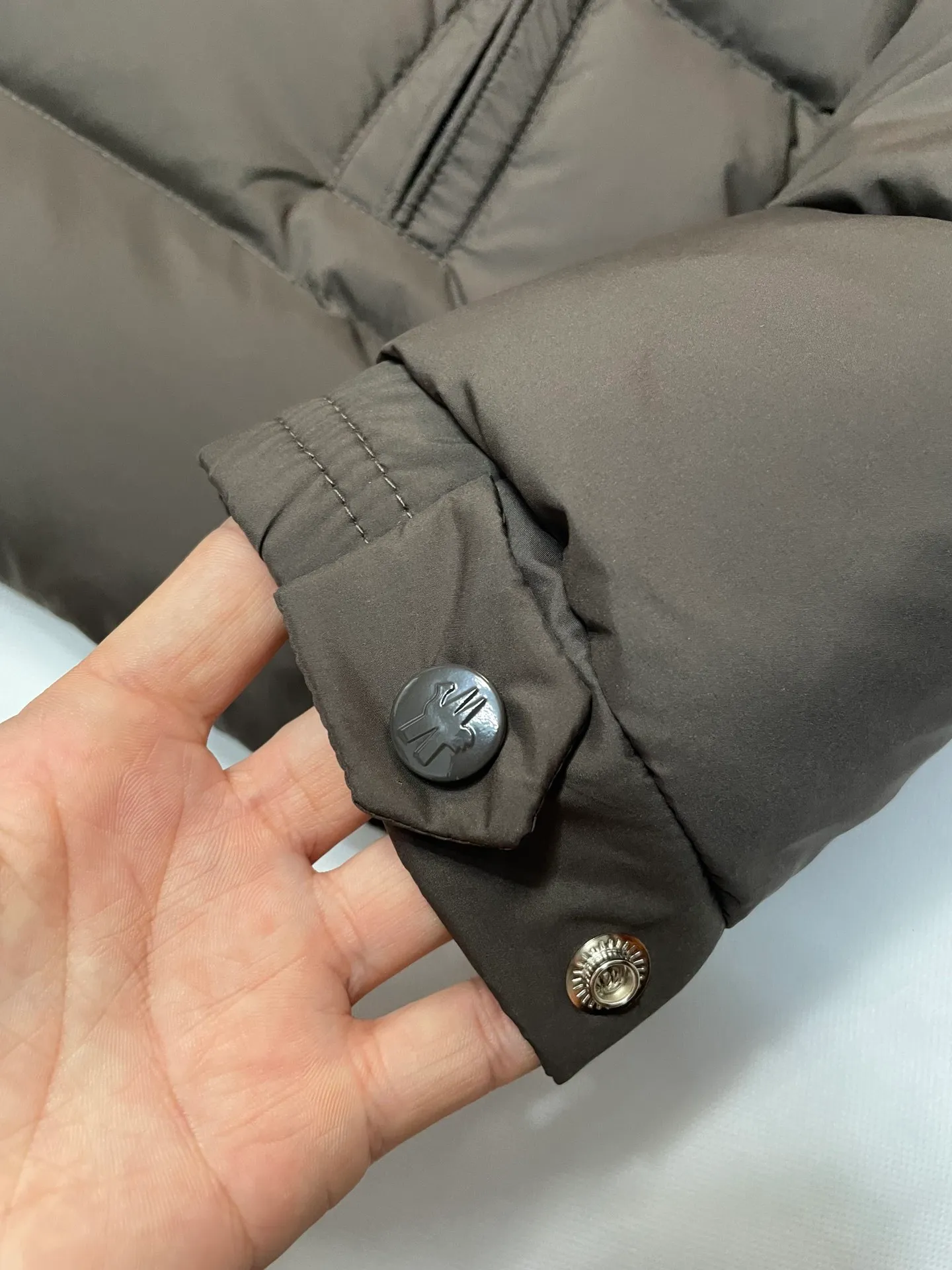 P840 🆕❤️2️⃣0️⃣2️⃣4️⃣🆕Premium down⬆️Moncler Solayan men's three-color trim short down jacket. Premium goose down filling. The finest, lightest and neatest fabric. Solayan men's short down jacket is decorated with seasonal iconic stripe details, blending sportsmanship and timeless style.  The Solayan down jacket is made of micro chic fabric and has a tough square shape design, highlighting Moncler's sporty spirit. This cropped down jacket features tricolor stripes on the sleeves, a seasonal take on the brand's signature. Comes with a practical pull-out hood. Details •Made from micro chic nylon fabric •Micro chic nylon lining •Down filled •Pull-out hood •Zip closure •Zip pockets •Adjustable cuffs •Elastic drawstring hem •Tri-color trim on sleeves Size: 1-5 Color: White Dark Brown Black