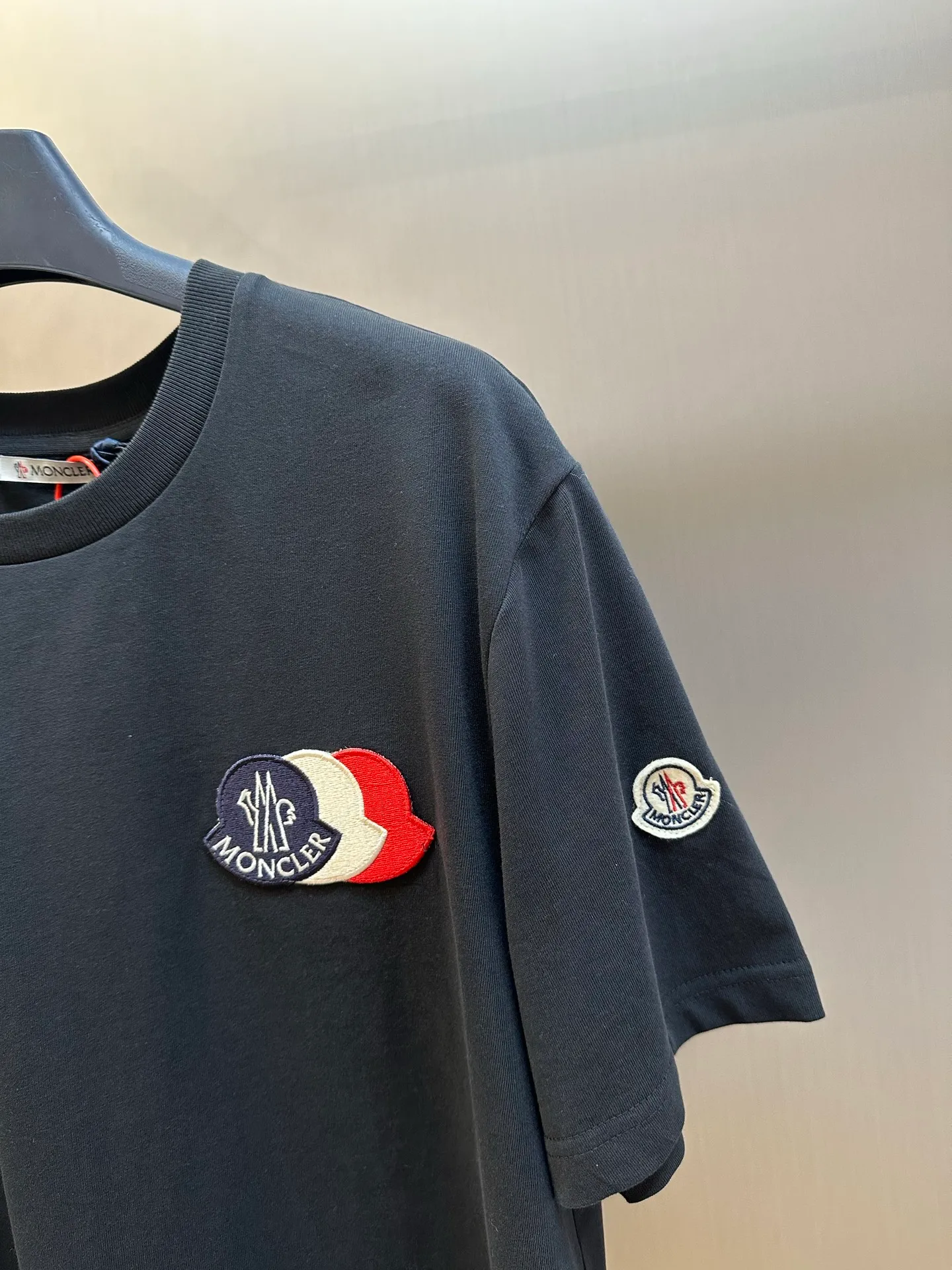 P230 Moncler short-sleeved patch logo, custom-made cloud-soft plain cotton fabric, with the iconic three-color design badge embellished on the chest, interpreting the visual grammar of modern luxury, and the Moncler embroidered logo on the side, highlighting the brand style.  Using imported machine embroidery technology, advanced computer control systems and precision mechanical components, Moncler embroidery logo embroidery operations are realized.  size：s m l xl