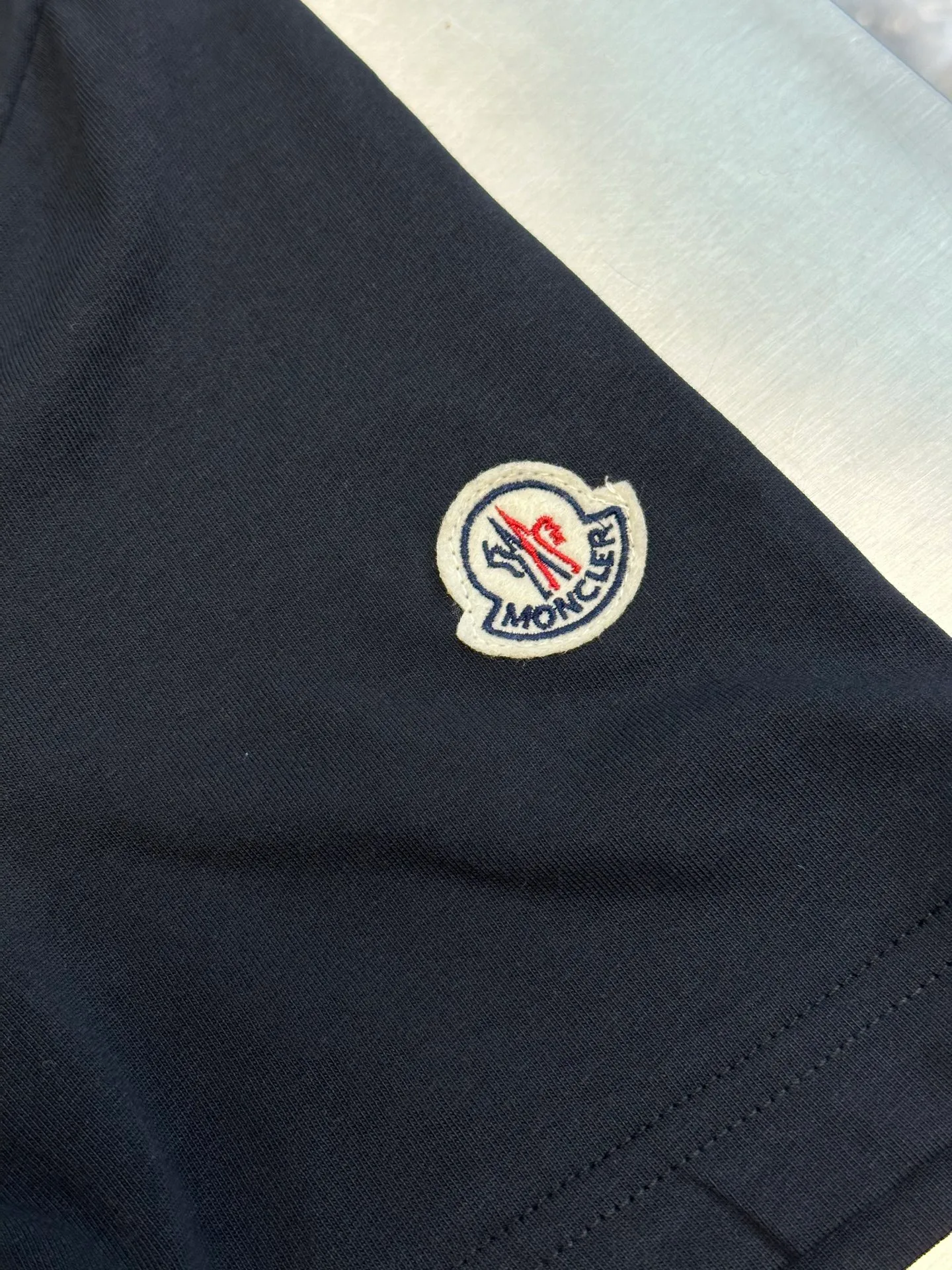 P230 Moncler short-sleeved patch logo, custom-made cloud-soft plain cotton fabric, with the iconic three-color design badge embellished on the chest, interpreting the visual grammar of modern luxury, and the Moncler embroidered logo on the side, highlighting the brand style.  Using imported machine embroidery technology, advanced computer control systems and precision mechanical components, Moncler embroidery logo embroidery operations are realized.  size：s m l xl