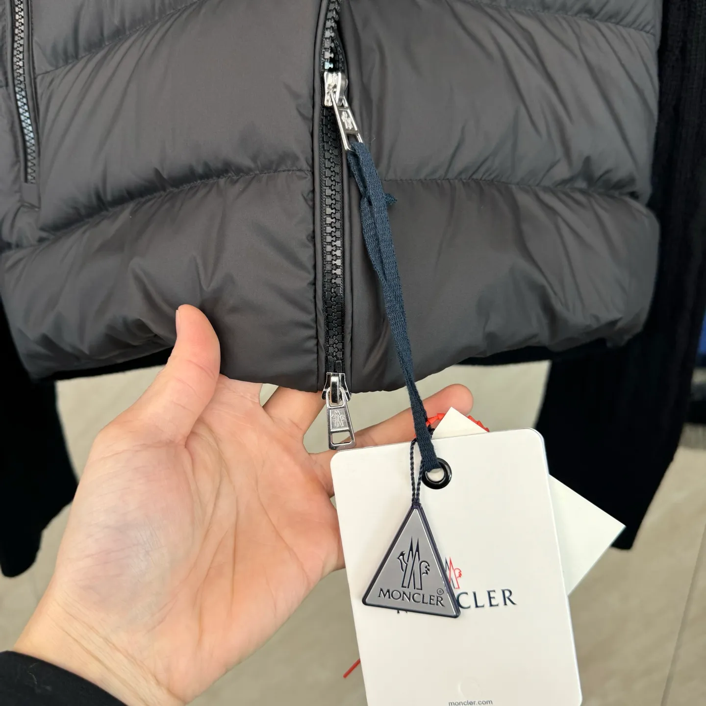 P810 Moncler Mouth Woolen Spliced ​​Down Jacket Size: 1 2 3 4 Fabric Selection: The outer front fabric is made of 100% nylon (nylon). Its high-density structure achieves excellent windproof effect. It also has strong wear resistance and wrinkle resistance. It is not afraid of scratches in daily wear and is easy to take care of.  The splicing design of sweaters and down jackets not only retains the thermal performance of down jackets, but also incorporates the fashion elements of sweaters, making the overall garment both practical and fashionable.  High-quality material: filled with high-quality white duck down, with a filling capacity of 100g, which has excellent thermal insulation effect. At the same time, the sweater is made of wool, cashmere and other natural fibers, which are soft, comfortable and skin-friendly.  The sweaters and down jackets are carefully spliced ​​to ensure comfortable wearing and are not prone to threading or velvet loss.  High collar design: not only provides excellent thermal insulation effect, but also adds a unique sense of fashion, allowing the wearer to maintain style in the cold season.  Stripe decoration: The stripes on the sleeve arms are like bright brush strokes, embellished on the dark gray down jacket, injecting vitality and movement into the overall look, making the clothing more eye-catching.  Accessories: one-to-one customized zipper puller, one-to-one customized armband