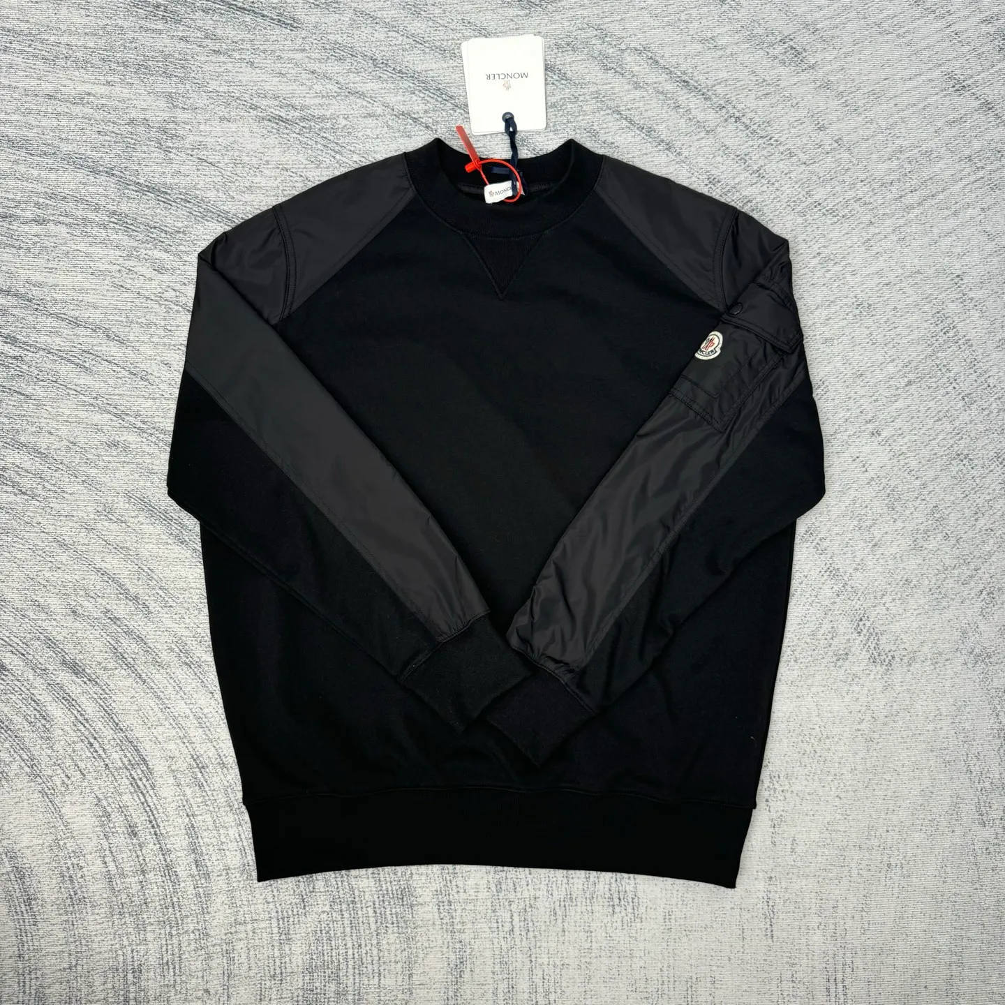 P420 Moncler logo patch pocket splicing sweatshirt SIZE S/M/L/XL Customized soft velvet cotton blended warm core material and tough nylon high-density woven material. Smooth and delicate, comfortable and close to the skin. With a deep black curtain as the base, a triangular world is quietly drawn on the chest. Iconic Moncler logo embroidery logo decorates the sleeves. Integrated nylon fabric to embellish the square silhouette. Cross-disciplinary aesthetic grafting. Exquisite small pocket design Revealing a flexible and relaxed beauty, deconstructing the attitude of modern gentlemen and showing taste in silence. Process 1: Needle and shuttle stitching technology can make full use of the respective advantages of knitted fabrics and woven fabrics. By choosing the appropriate sewing process and stitches, the splicing parts can be ensured to be strong and beautiful. Process 2: Template machine bag opening. The preset template guides the position, shape and size of the bag opening. The accuracy ensures the quality of the bag opening effect. Process 3: The fabrics are washed and have a better hand feel. Not easy to deform, not easy to shrink, not easy to fade, maintain long-term beauty