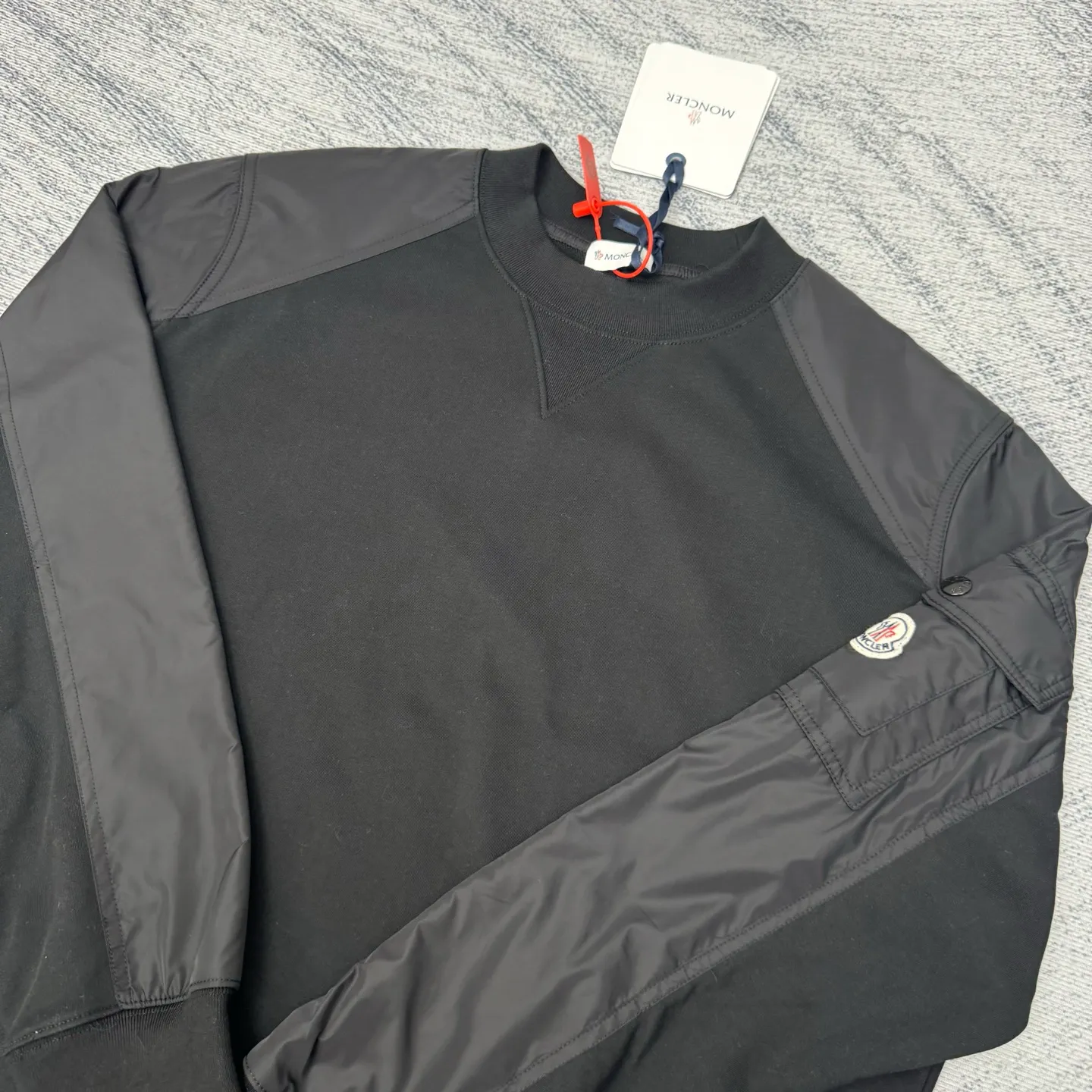 P420 Moncler logo patch pocket splicing sweatshirt SIZE S/M/L/XL Customized soft velvet cotton blended warm core material and tough nylon high-density woven material. Smooth and delicate, comfortable and close to the skin. With a deep black curtain as the base, a triangular world is quietly drawn on the chest. Iconic Moncler logo embroidery logo decorates the sleeves. Integrated nylon fabric to embellish the square silhouette. Cross-disciplinary aesthetic grafting. Exquisite small pocket design Revealing a flexible and relaxed beauty, deconstructing the attitude of modern gentlemen and showing taste in silence. Process 1: Needle and shuttle stitching technology can make full use of the respective advantages of knitted fabrics and woven fabrics. By choosing the appropriate sewing process and stitches, the splicing parts can be ensured to be strong and beautiful. Process 2: Template machine bag opening. The preset template guides the position, shape and size of the bag opening. The accuracy ensures the quality of the bag opening effect. Process 3: The fabrics are washed and have a better hand feel. Not easy to deform, not easy to shrink, not easy to fade, maintain long-term beauty