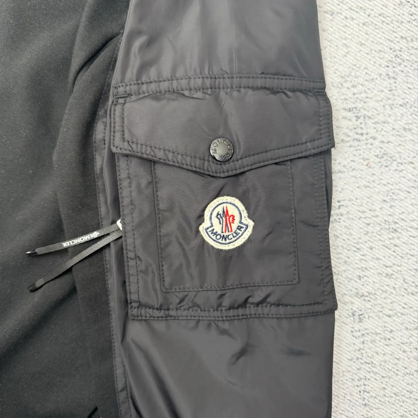 P420 Moncler logo patch pocket splicing sweatshirt SIZE S/M/L/XL Customized soft velvet cotton blended warm core material and tough nylon high-density woven material. Smooth and delicate, comfortable and close to the skin. With a deep black curtain as the base, a triangular world is quietly drawn on the chest. Iconic Moncler logo embroidery logo decorates the sleeves. Integrated nylon fabric to embellish the square silhouette. Cross-disciplinary aesthetic grafting. Exquisite small pocket design Revealing a flexible and relaxed beauty, deconstructing the attitude of modern gentlemen and showing taste in silence. Process 1: Needle and shuttle stitching technology can make full use of the respective advantages of knitted fabrics and woven fabrics. By choosing the appropriate sewing process and stitches, the splicing parts can be ensured to be strong and beautiful. Process 2: Template machine bag opening. The preset template guides the position, shape and size of the bag opening. The accuracy ensures the quality of the bag opening effect. Process 3: The fabrics are washed and have a better hand feel. Not easy to deform, not easy to shrink, not easy to fade, maintain long-term beauty