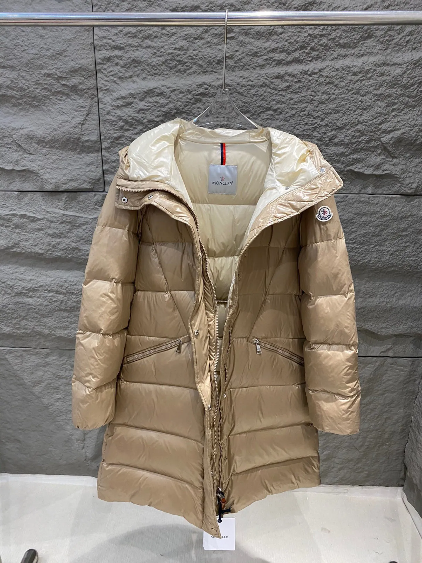 P1180 Moncler Bellevue Women's Long Belted Down Jacket The Bellevue down jacket is made of iconic nylon laqué fabric, interpreting classic Moncler style. Long design, the fabric has been functionally treated for a gorgeous lustrous effect. This hooded thermal piece has a feminine silhouette and an elastic waistband. From day to night, from the city to the mountains, it can be easily handled. Color: black/khaki Size: 0/1/2/3