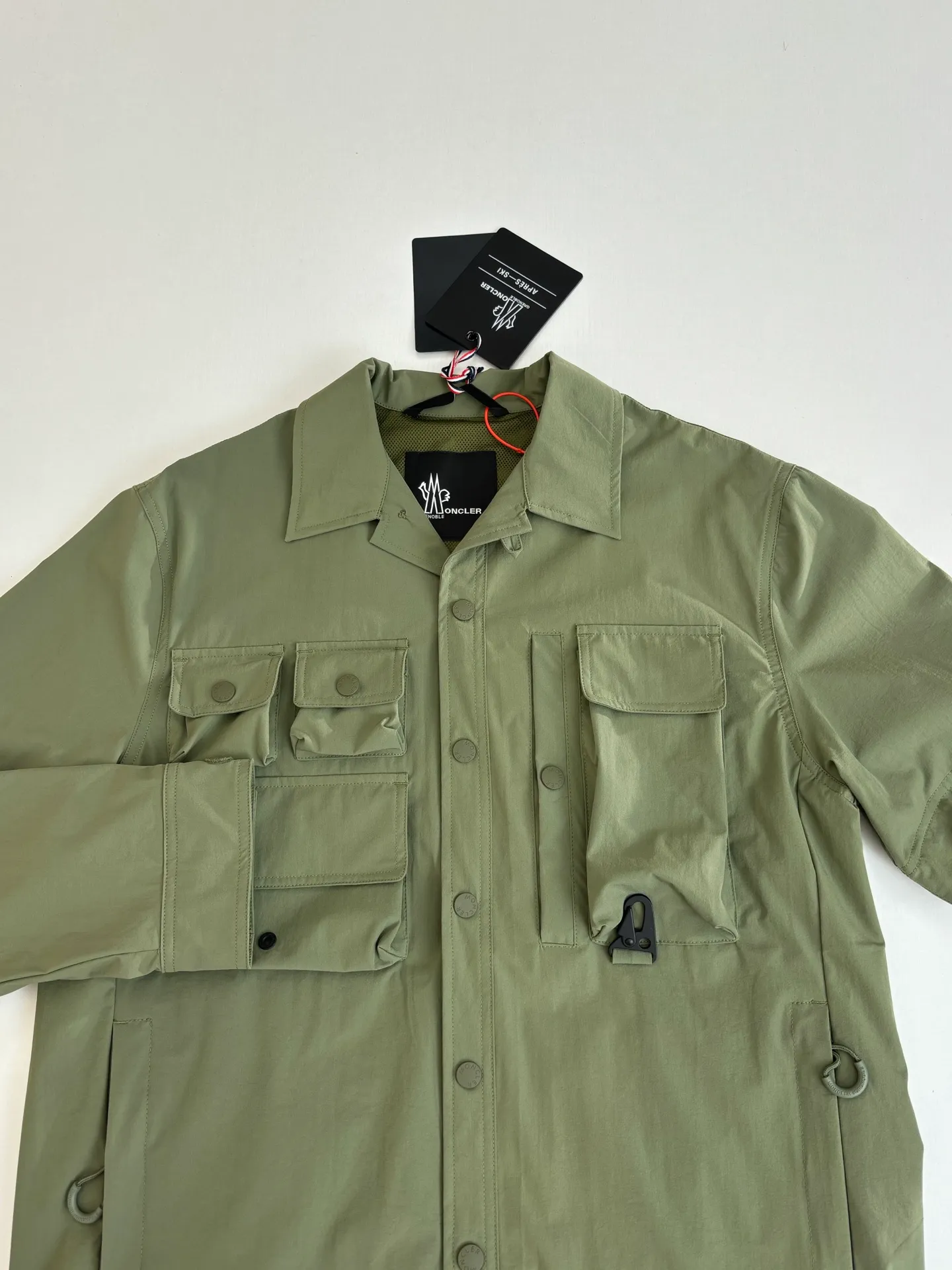 P650 Moncle*/Mask Grenoble functional outdoor zippered jacket with adjustable sleeves. Custom-dyed double-stretch mercerized poplin. Custom-dyed soft mesh pongee. Excellent texture. Comfortable and close to the skin. Dark green inspired by plant texture. The color is taken from sage leaves soaked in morning dew. Precise narrative of functional pocket system. Functional and aesthetic balance. Iconic Moncler logo appears on the sleeves, fully recognizable. The triangular logo of the same color is hidden into the fabric texture like a mark in the undercurrent of the deep sea. It is extremely invisible and visible. The detachable sleeve design allows for diversified outfits. Size: 1/2/3/4