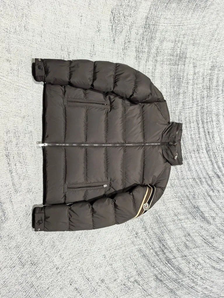 P880 Style number: Y121 Moncler Solayan men's three-color trimmed short down jacket! The latest official website is available simultaneously! ! White duck down filling ~ the most delicate, light and neat fabric!  The Solayan Men's Short Down Jacket features the season's signature stripe detailing, blending sporty spirit with timeless style.  The Solayan down jacket is made of micro chic fabric and has a tough square shape design, highlighting Moncler's sporty spirit. This cropped down jacket features tricolor stripes on the sleeves, a seasonal take on the brand's signature. Comes with a practical pull-out hood. Color: Black Royal Blue Brown Size: 1-2-3-4-5