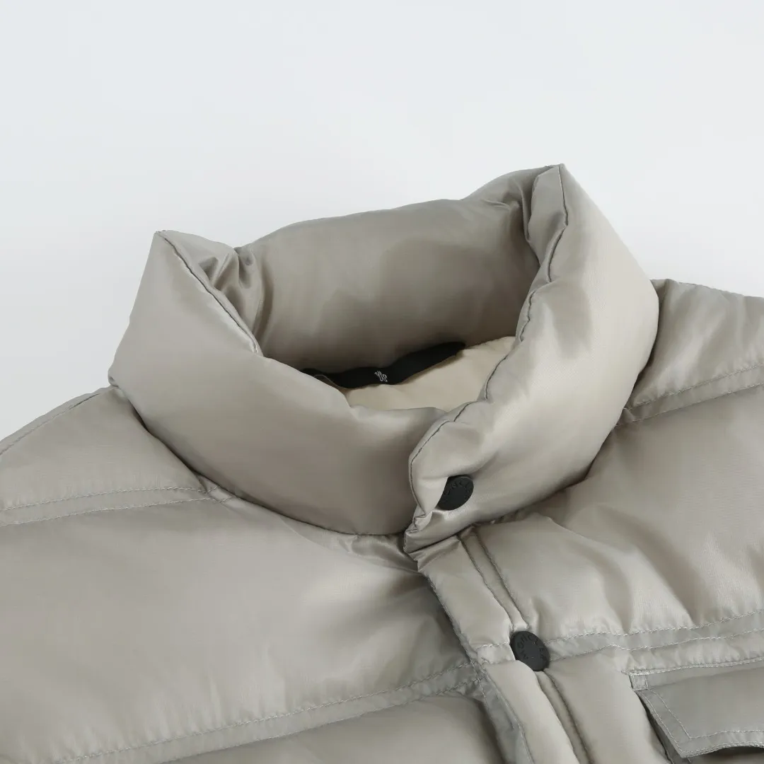 P680 MONCLER down vest with reflective markings Fabric selection: Made of ultra-fine nylon yarn woven in a high-density manner. The number of yarns per unit area is large, and the gaps between the yarns are very small, which can effectively block the penetration of cold wind. The fine weave keeps it lightweight and soft to the touch, physically restricting the lightweight down fibers from slipping through the gaps. Nylon fiber itself has good wear resistance and is not easy to snag, which significantly extends its service life and can easily cope with the needs of multiple scenarios.  Lining selection: The lining is made of 100% polyester fiber high-density weaving. The thickness of 0.08mm avoids increasing the overall weight and makes it smooth to wear. The high-density weaving structure forms a wind resistance layer to protect the thermal efficiency of the thermal insulation layer from loss. At the same time, it can withstand the expansion pressure of down and prevent deformation and damage after long-term use.  High-quality filling: 90 white duck down is selected, with a weight of 130g, ensuring excellent thermal insulation performance. After strict screening and processing, the velvet is not easy to get drilled, ensuring durability.  Process: Through the reflective cloth punching process, the logo is regularly arranged on the triangular reflective mark with dozens of small holes, which not only improves the functionality, but also strengthens the recognition and aesthetics.   Accessories: One-to-one customized snap buttons, one-to-one customized zipper pullers, one-to-one customized badges, one-to-one customized elastic buckles, etc. SIZE: 1 2 3 4