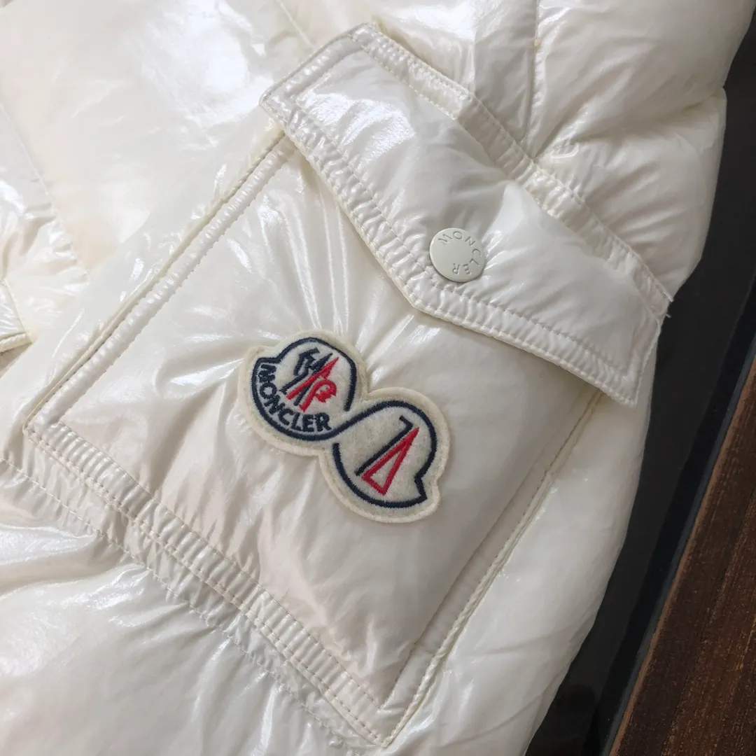 P800 Moncler Maya 70 Short Down Jacket Ivory The iconic men's Moncler Maya 70 down jacket is highly recognizable and is specially designed to celebrate the brand's 70th anniversary. The Moncler Maya down jacket has been reinterpreted specifically to celebrate Moncler's 70th anniversary, and the iconic silhouette has been refreshed in new colors. A classic example of the brand's DNA, it's made from shiny lacquered nylon and embellished with signature rectangular quilting. A classic, cropped design that spans seasons and fashions, the removable hood features a statement silhouette, removable hood and adjustable hem. The sleeves are decorated with the brand's signature classic patch pockets and a patchwork logo designed to celebrate the 70th anniversary. Color: black, ivory white, basalt gray, purple, cabin brown, forest green, code number: 1-2-3-4-5 (M～3xl)