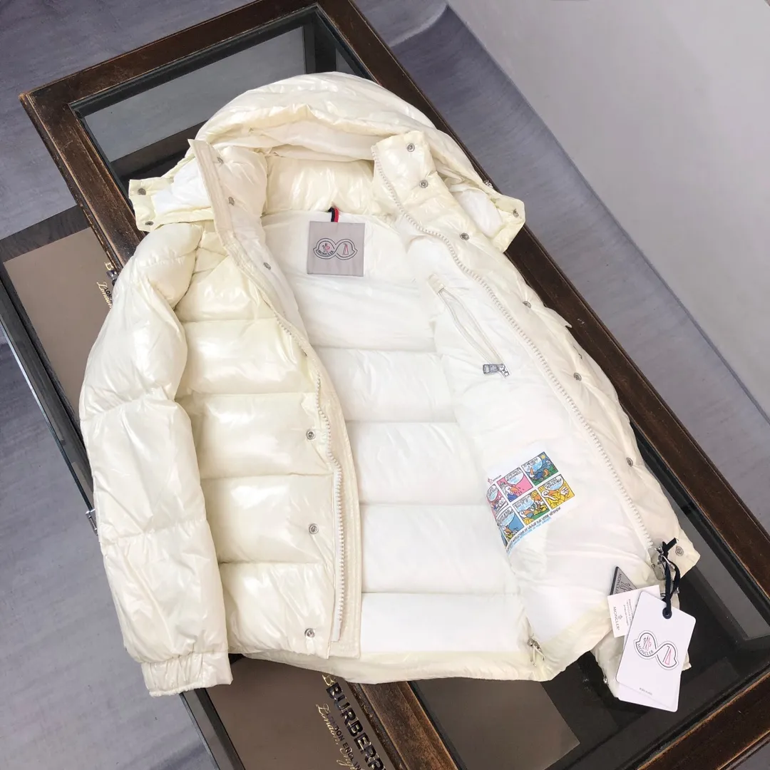 P800 Moncler Maya 70 Short Down Jacket Ivory The iconic men's Moncler Maya 70 down jacket is highly recognizable and is specially designed to celebrate the brand's 70th anniversary. The Moncler Maya down jacket has been reinterpreted specifically to celebrate Moncler's 70th anniversary, and the iconic silhouette has been refreshed in new colors. A classic example of the brand's DNA, it's made from shiny lacquered nylon and embellished with signature rectangular quilting. A classic, cropped design that spans seasons and fashions, the removable hood features a statement silhouette, removable hood and adjustable hem. The sleeves are decorated with the brand's signature classic patch pockets and a patchwork logo designed to celebrate the 70th anniversary. Color: black, ivory white, basalt gray, purple, cabin brown, forest green, code number: 1-2-3-4-5 (M～3xl)