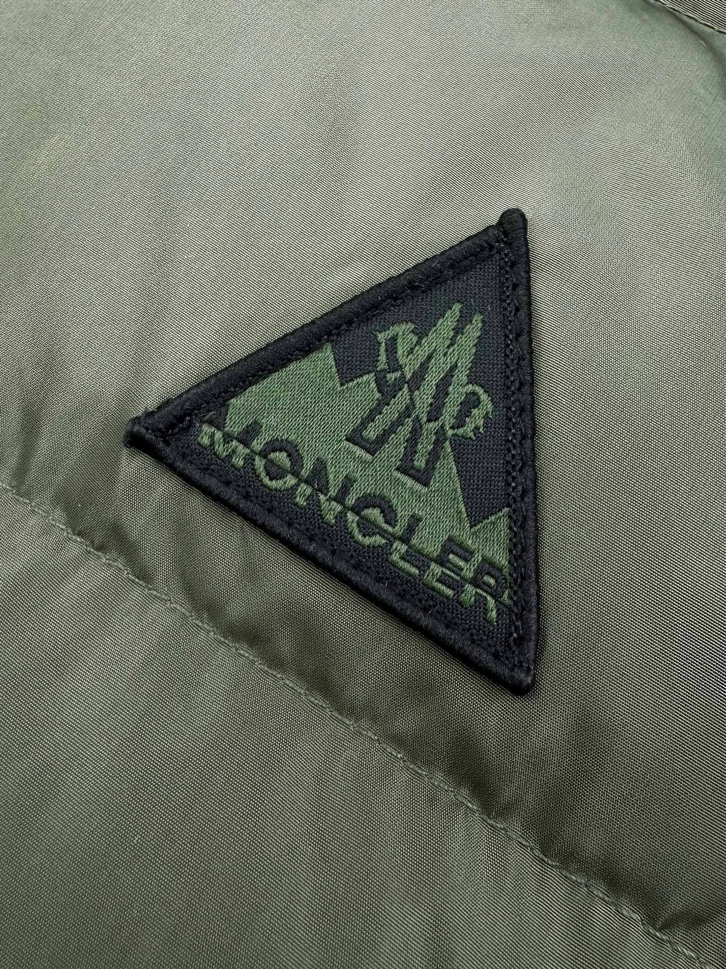 P780 Moncler logo woven splicing down jacket, custom-made matte lattice air shield down and 300D high-density calendered coating, using the new national standard 90 white duck down (welcome to test), full of down, full of warmth, light and fluffy, with the dark green of the overlapping mountains as the background, all things accumulating, creating its own scenery in silence The Monlcer triangle logo is embellished on the chest, the power aesthetics of the minimalist logo The concentrated down filling in the front area creates dynamic insulation for the core heat dissipation zone of the human body. The hooded down is a moving warm flow barrier for the head and neck, forming a thermal energy circulation system with the front area. The elastic woven sleeves provide freedom of movement with a sense of compression, forming a relaxed and warm philosophy. The real high-end is to let function become the footnote of style. Process 1: Computer mechanical down filling. Prioritize the liner pattern by making a pattern to determine the down filling area and determine the weight of down per square meter according to the original three-dimensional effect. Thus, the amount of down filling for each cut piece is calculated. The computer down filling machine uses a digital weighing unit to achieve stable measurement. Process 2: 3D three-dimensional quilting technology. With the programming system of the CNC quilting machine, the down in different areas is accurately separated to ensure that the filling is evenly fixed after sewing and avoid agglomeration or displacement. Process 3: Computer template machine line running process. The computer template machine line line process shows extremely high neatness and smoothness. The craftsman's precise control of the size during the operation ensures that each line meets the design requirements. The lines of the entire template are smooth and unified, neat and beautiful. Process 4: Triple locking five-thread dense stitching process. Main seam locking + diagonal reinforcement + raw edge wrapping. Triple structure to form a three-dimensional protective net at the edge of the fabric to avoid stitch breakage. Paving materials: Customized 1:1 Moncler zipper. Customized 1:1 Moncler rope loop. Customized 1:1 Moncler logo. Customized 1:1 Moncler. Corns Customized 1:1 Moncler trademark Size: S M L XL Style number: 25378