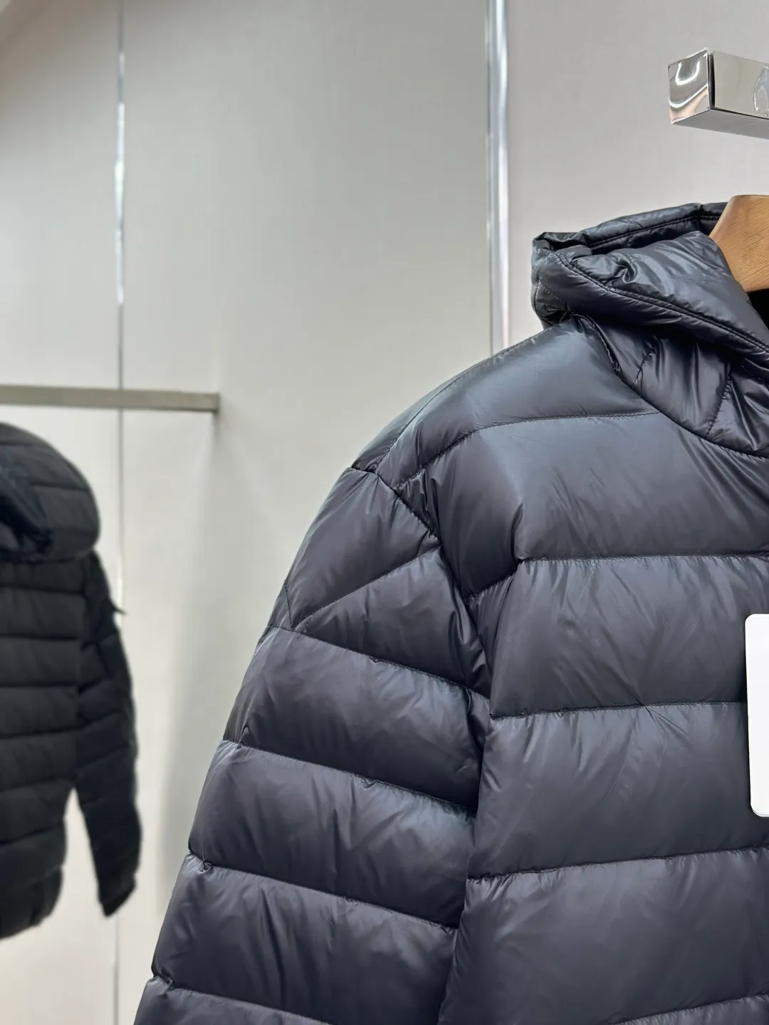 P910 MONCLER hooded brim quilted embroidered down jacket Fabric selection: The longue saison fabric is made of high-count polyamide fiber, which is known for its excellent tensile strength and lightness. Its good flexibility makes the fabric less prone to wrinkles and keeps it crisp and stylish for a long time. The tight weave effectively blocks the invasion of cold wind and locks in the warm air generated by the down layer. The high-density nylon surface forms a certain lotus leaf effect, making it difficult for small water droplets to penetrate, keeping the interior dry and effectively extending the service life of the down.  Lining selection: High-density lining fabric made of ultra-fine denier, 0.08mm thickness to avoid increasing the overall weight and making it smooth to wear. The high-density woven structure forms a wind resistance layer to protect the thermal efficiency of the thermal layer from loss. It can also withstand the expansion pressure of down and prevent deformation and damage after long-term use.  Technology: The quilted letter logo on the brim uses contour quilting technology. The stitching is routed along the edge of the set outline, and the filler is compressed inside the letter graphic, so that the logo is three-dimensional and convex, and the pattern is clear.  High-quality filling: It is filled with 90% selected white duck down, weighing 210g, ensuring fluffy rebound, lightness and warmth.  Accessories: customized zipper pendant, customized badge, customized three-label SIZE: 1 2 3 4