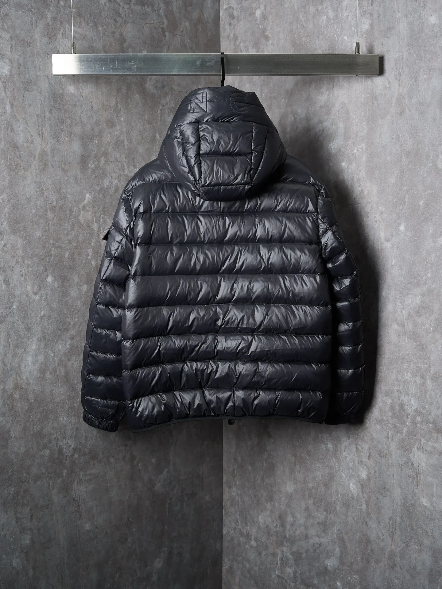 P900 Actual hanging auction] MONCLER/Maskled brim quilted embroidered pocket logo hooded down jacket [Ready stock] 1 2 3 4 Filled with 90 selected white duck down, weighing 210g, ensuring fast fluffy rebound, lightness and warmth.  The longue saison fabric made of high-count polyamide fiber is famous for its excellent tensile strength and lightness. Its good flexibility makes the fabric less prone to wrinkles and keeps it crisp and stylish for a long time. The tight weave effectively blocks the invasion of cold wind and locks in the warm air generated by the down layer. The high-density nylon surface forms a certain lotus leaf effect, making it difficult for small water droplets to penetrate, keeping the interior dry and effectively extending the service life of the down.  The high-density lining is woven with ultra-fine denier, with a thickness of 0.08mm to avoid increasing the overall weight and making it smooth to wear. The high-density woven structure forms a wind resistance layer to protect the thermal efficiency of the thermal layer from loss. It can also withstand the expansion pressure of down and prevent deformation and damage after long-term use.  The quilted letter logo on the brim uses contour quilting technology. The stitches are routed along the edge of the set outline, and the filler is compressed inside the letter graphic, so that the logo is three-dimensional and the pattern is clear.