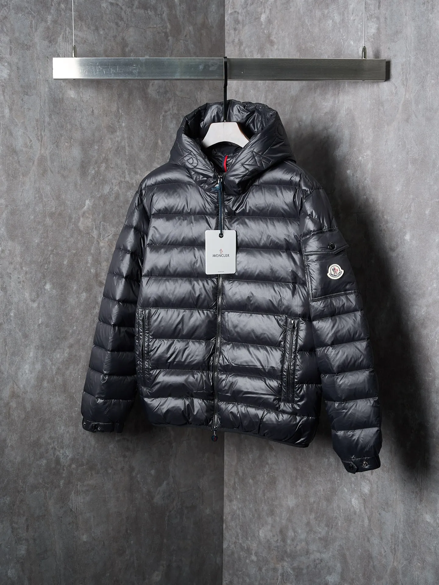 P900 Actual hanging auction] MONCLER/Maskled brim quilted embroidered pocket logo hooded down jacket [Ready stock] 1 2 3 4 Filled with 90 selected white duck down, weighing 210g, ensuring fast fluffy rebound, lightness and warmth.  The longue saison fabric made of high-count polyamide fiber is famous for its excellent tensile strength and lightness. Its good flexibility makes the fabric less prone to wrinkles and keeps it crisp and stylish for a long time. The tight weave effectively blocks the invasion of cold wind and locks in the warm air generated by the down layer. The high-density nylon surface forms a certain lotus leaf effect, making it difficult for small water droplets to penetrate, keeping the interior dry and effectively extending the service life of the down.  The high-density lining is woven with ultra-fine denier, with a thickness of 0.08mm to avoid increasing the overall weight and making it smooth to wear. The high-density woven structure forms a wind resistance layer to protect the thermal efficiency of the thermal layer from loss. It can also withstand the expansion pressure of down and prevent deformation and damage after long-term use.  The quilted letter logo on the brim uses contour quilting technology. The stitches are routed along the edge of the set outline, and the filler is compressed inside the letter graphic, so that the logo is three-dimensional and the pattern is clear.