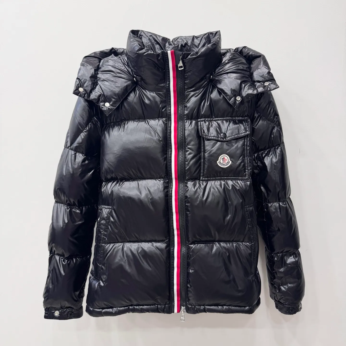 P800 [Montbeliard men's hooded web short down jacket] This Montbeliard men's short down jacket is made of glossy nylon laqué fabric, interpreting the classic Moncler style.      The Montbeliard down jacket is made from signature nylon laqué fabric with a gorgeous lustrous effect. Equipped with a removable hood, it can easily adapt to changing weather. The sleeve pockets inspired by Moncler Maya are embellished to highlight the brand's essence.  - Made of nylon laqué - Nylon laqué lining - Down filling - Detachable and adjustable hood - Zip fastening - Zippered pockets - Press buttons on chest pocket - Press buttons on sleeve pockets - Adjustable cuffs - Drawstring hem - Fabric: 100% nylon; - Lining: 100% nylon; - Hood lining: 100% nylon; - Filling: goose down - Down content: 90%; - Except for upholstery; - Sizes: 1 2 3 4 5 Maximum wash temperature 30°C - Wash on gentle cycle; Do not bleach; Do not tumble dry; Iron maximum temperature 110°C - Without steam; Do not dry clean; Professional wet clean - Wash on gentle cycle; Lay flat to dry in shade; Wash separately; Remove removable accessories before washing; Recommended to wash and iron inside out; Do not iron accessories