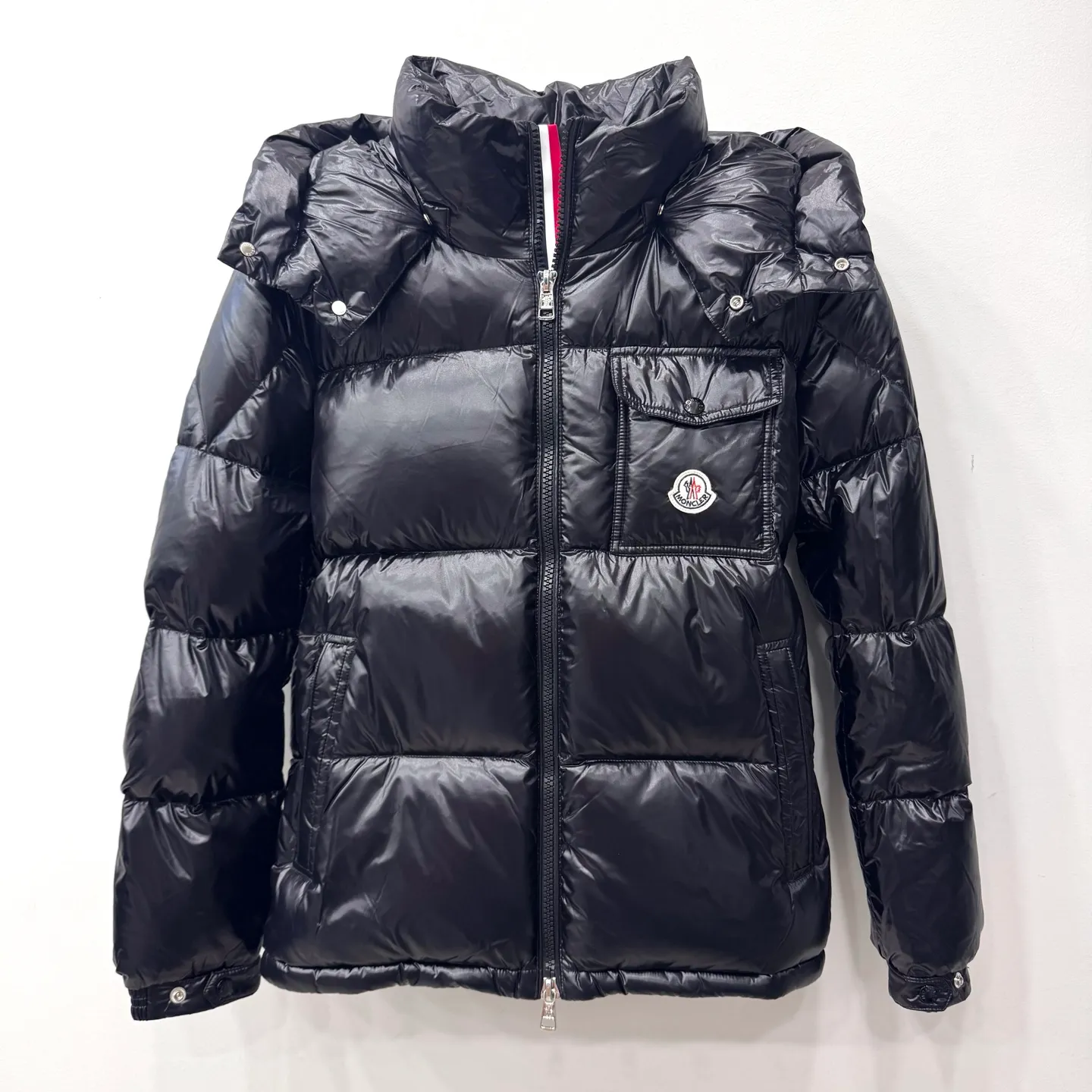 P800 [Montbeliard men's hooded web short down jacket] This Montbeliard men's short down jacket is made of glossy nylon laqué fabric, interpreting the classic Moncler style.      The Montbeliard down jacket is made from signature nylon laqué fabric with a gorgeous lustrous effect. Equipped with a removable hood, it can easily adapt to changing weather. The sleeve pockets inspired by Moncler Maya are embellished to highlight the brand's essence.  - Made of nylon laqué - Nylon laqué lining - Down filling - Detachable and adjustable hood - Zip fastening - Zippered pockets - Press buttons on chest pocket - Press buttons on sleeve pockets - Adjustable cuffs - Drawstring hem - Fabric: 100% nylon; - Lining: 100% nylon; - Hood lining: 100% nylon; - Filling: goose down - Down content: 90%; - Except for upholstery; - Sizes: 1 2 3 4 5 Maximum wash temperature 30°C - Wash on gentle cycle; Do not bleach; Do not tumble dry; Iron maximum temperature 110°C - Without steam; Do not dry clean; Professional wet clean - Wash on gentle cycle; Lay flat to dry in shade; Wash separately; Remove removable accessories before washing; Recommended to wash and iron inside out; Do not iron accessories