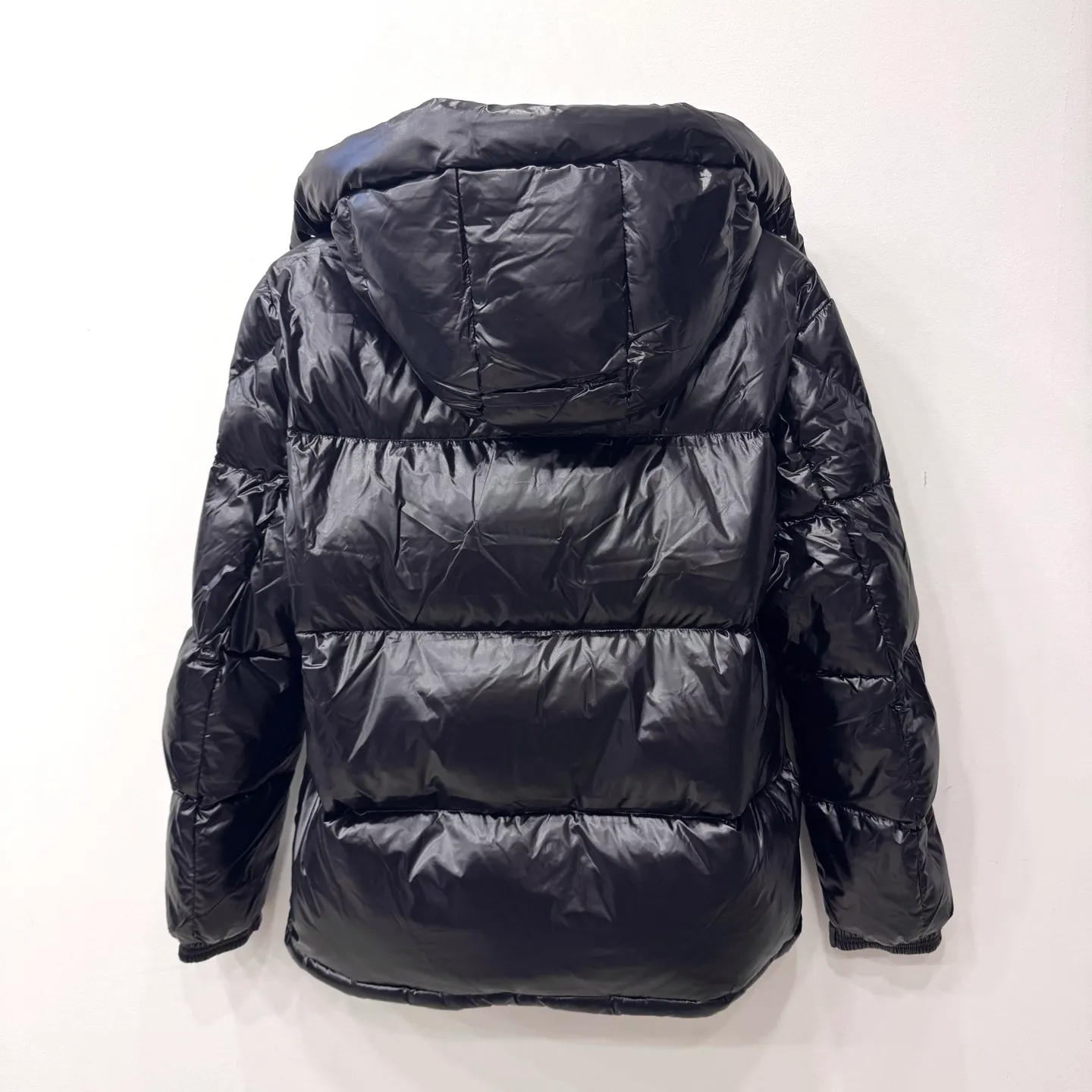 P800 [Montbeliard men's hooded web short down jacket] This Montbeliard men's short down jacket is made of glossy nylon laqué fabric, interpreting the classic Moncler style.      The Montbeliard down jacket is made from signature nylon laqué fabric with a gorgeous lustrous effect. Equipped with a removable hood, it can easily adapt to changing weather. The sleeve pockets inspired by Moncler Maya are embellished to highlight the brand's essence.  - Made of nylon laqué - Nylon laqué lining - Down filling - Detachable and adjustable hood - Zip fastening - Zippered pockets - Press buttons on chest pocket - Press buttons on sleeve pockets - Adjustable cuffs - Drawstring hem - Fabric: 100% nylon; - Lining: 100% nylon; - Hood lining: 100% nylon; - Filling: goose down - Down content: 90%; - Except for upholstery; - Sizes: 1 2 3 4 5 Maximum wash temperature 30°C - Wash on gentle cycle; Do not bleach; Do not tumble dry; Iron maximum temperature 110°C - Without steam; Do not dry clean; Professional wet clean - Wash on gentle cycle; Lay flat to dry in shade; Wash separately; Remove removable accessories before washing; Recommended to wash and iron inside out; Do not iron accessories