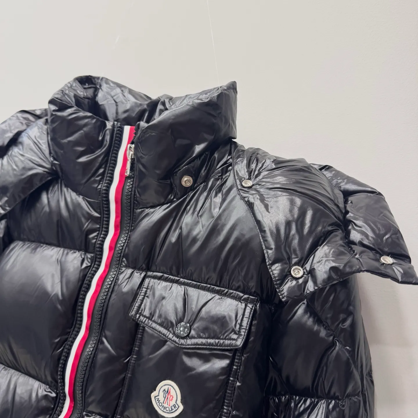 P800 [Montbeliard men's hooded web short down jacket] This Montbeliard men's short down jacket is made of glossy nylon laqué fabric, interpreting the classic Moncler style.      The Montbeliard down jacket is made from signature nylon laqué fabric with a gorgeous lustrous effect. Equipped with a removable hood, it can easily adapt to changing weather. The sleeve pockets inspired by Moncler Maya are embellished to highlight the brand's essence.  - Made of nylon laqué - Nylon laqué lining - Down filling - Detachable and adjustable hood - Zip fastening - Zippered pockets - Press buttons on chest pocket - Press buttons on sleeve pockets - Adjustable cuffs - Drawstring hem - Fabric: 100% nylon; - Lining: 100% nylon; - Hood lining: 100% nylon; - Filling: goose down - Down content: 90%; - Except for upholstery; - Sizes: 1 2 3 4 5 Maximum wash temperature 30°C - Wash on gentle cycle; Do not bleach; Do not tumble dry; Iron maximum temperature 110°C - Without steam; Do not dry clean; Professional wet clean - Wash on gentle cycle; Lay flat to dry in shade; Wash separately; Remove removable accessories before washing; Recommended to wash and iron inside out; Do not iron accessories