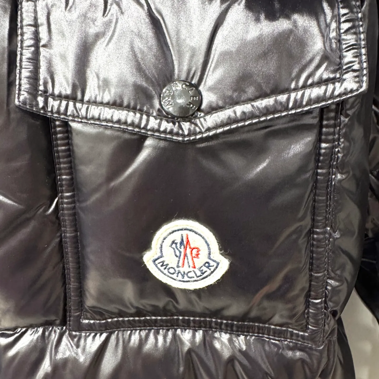 P800 [Montbeliard men's hooded web short down jacket] This Montbeliard men's short down jacket is made of glossy nylon laqué fabric, interpreting the classic Moncler style.      The Montbeliard down jacket is made from signature nylon laqué fabric with a gorgeous lustrous effect. Equipped with a removable hood, it can easily adapt to changing weather. The sleeve pockets inspired by Moncler Maya are embellished to highlight the brand's essence.  - Made of nylon laqué - Nylon laqué lining - Down filling - Detachable and adjustable hood - Zip fastening - Zippered pockets - Press buttons on chest pocket - Press buttons on sleeve pockets - Adjustable cuffs - Drawstring hem - Fabric: 100% nylon; - Lining: 100% nylon; - Hood lining: 100% nylon; - Filling: goose down - Down content: 90%; - Except for upholstery; - Sizes: 1 2 3 4 5 Maximum wash temperature 30°C - Wash on gentle cycle; Do not bleach; Do not tumble dry; Iron maximum temperature 110°C - Without steam; Do not dry clean; Professional wet clean - Wash on gentle cycle; Lay flat to dry in shade; Wash separately; Remove removable accessories before washing; Recommended to wash and iron inside out; Do not iron accessories