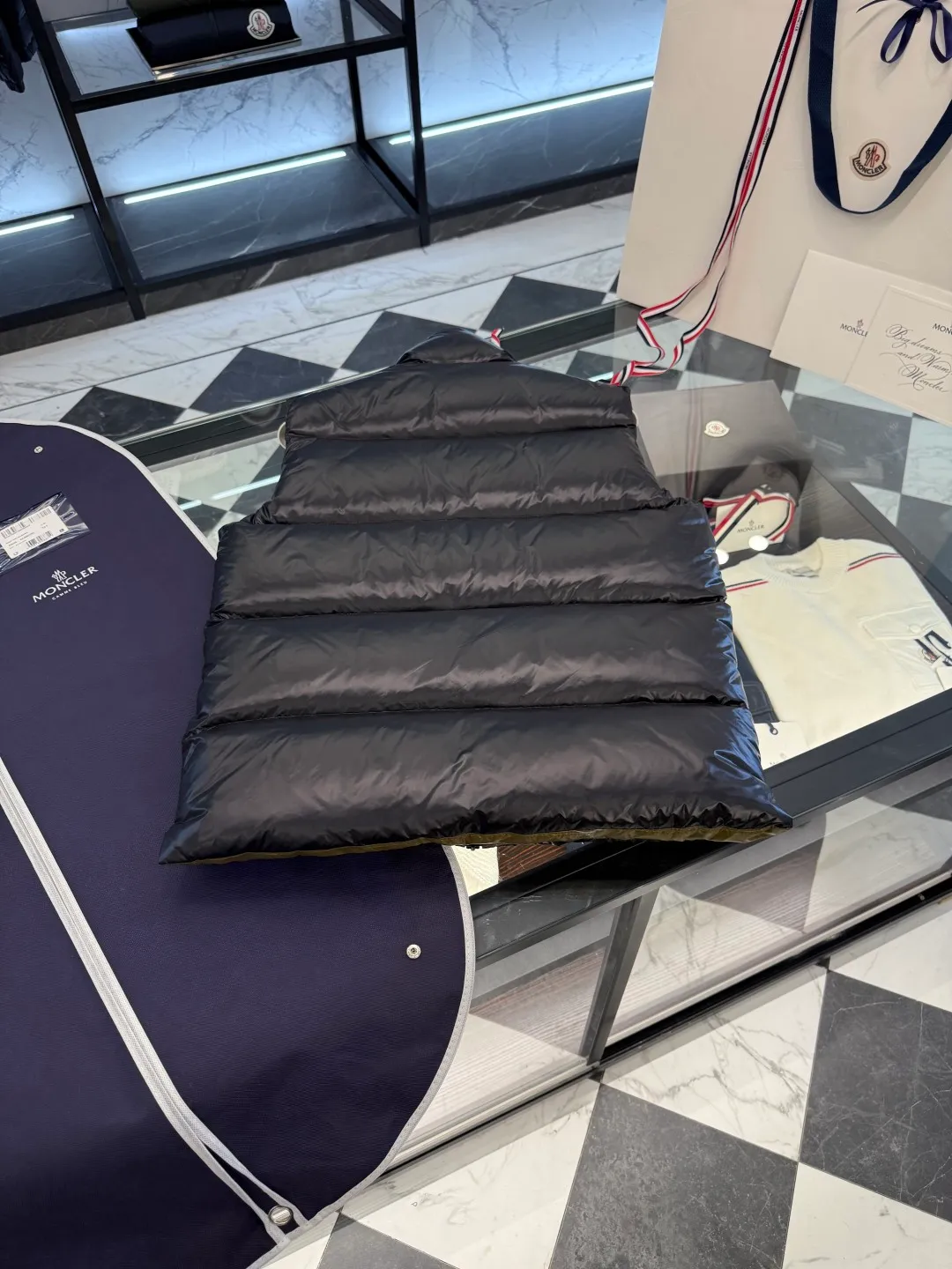 P660 Moncler Lipsi down vest. Contrast color splicing design. Super full filling. Lipsi men's down vest is made of shiny nylon laqué fabric, suitable for wearing in different seasons, bringing warmth and care.  The Lipsi short down vest embodies Moncler's classic design and is a must-have item for your wardrobe from season to season. Crafted from lightweight, functional nylon laqué fabric, it has a contrast lining for a vibrant feel. Details •Made from lightweight nylon laqué fabric •Lightweight nylon laqué lining •Filled with down •Stand-up collar •Zipper closure •Zip pockets •Chenille logo patch Size: 1-5 Black/Ivory Couple Style