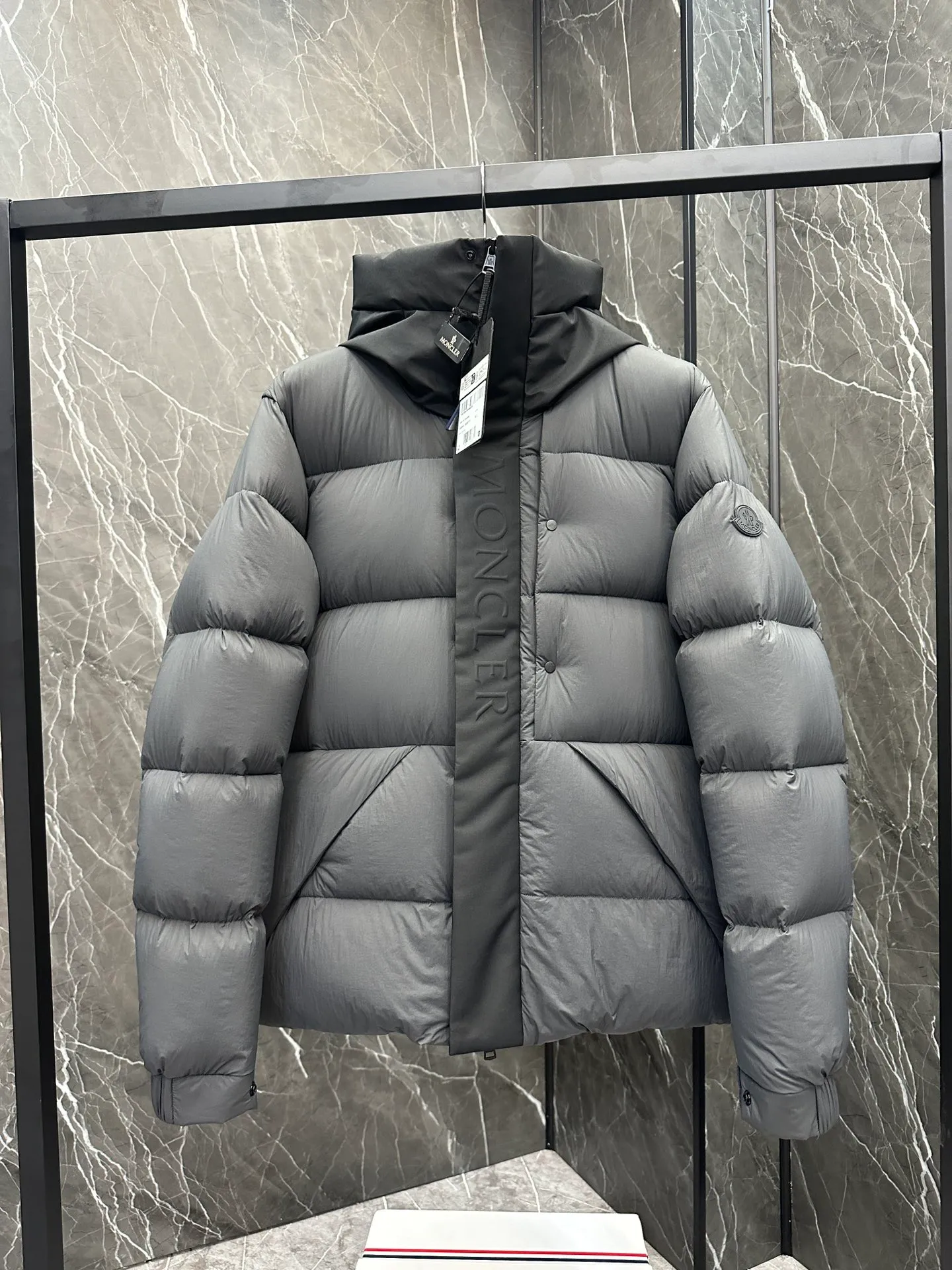 P760 Style number: Y125 Moncler Madeira short men's Madeira down jacket is specially designed for modern men who value functionality and beauty. It is suitable for wearing in various occasions such as street or skiing. Made from functional, tight nylon longue saison fabric with a padded hood and windshield for added protection. Details •Made in longue saison fabric •Nylon laqué lining •Filled with down •Hood •Embossed logo lettering •Snap and zipper closure •Pockets with zippers and snaps •Elastic drawstring hem •Logo patch Size: 1-5 Color: Black Gray White