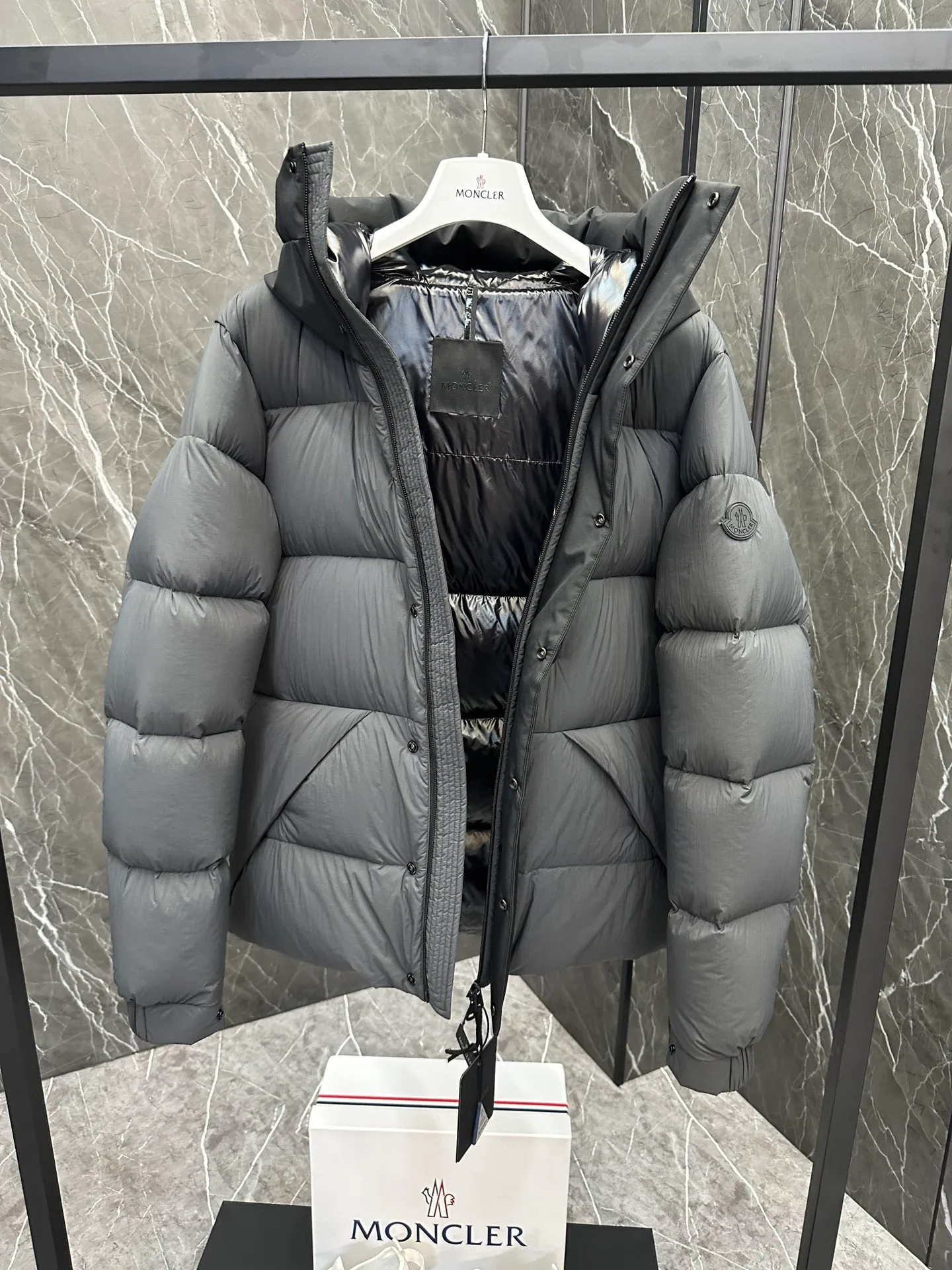 P760 Style number: Y125 Moncler Madeira short men's Madeira down jacket is specially designed for modern men who value functionality and beauty. It is suitable for wearing in various occasions such as street or skiing. Made from functional, tight nylon longue saison fabric with a padded hood and windshield for added protection. Details •Made in longue saison fabric •Nylon laqué lining •Filled with down •Hood •Embossed logo lettering •Snap and zipper closure •Pockets with zippers and snaps •Elastic drawstring hem •Logo patch Size: 1-5 Color: Black Gray White