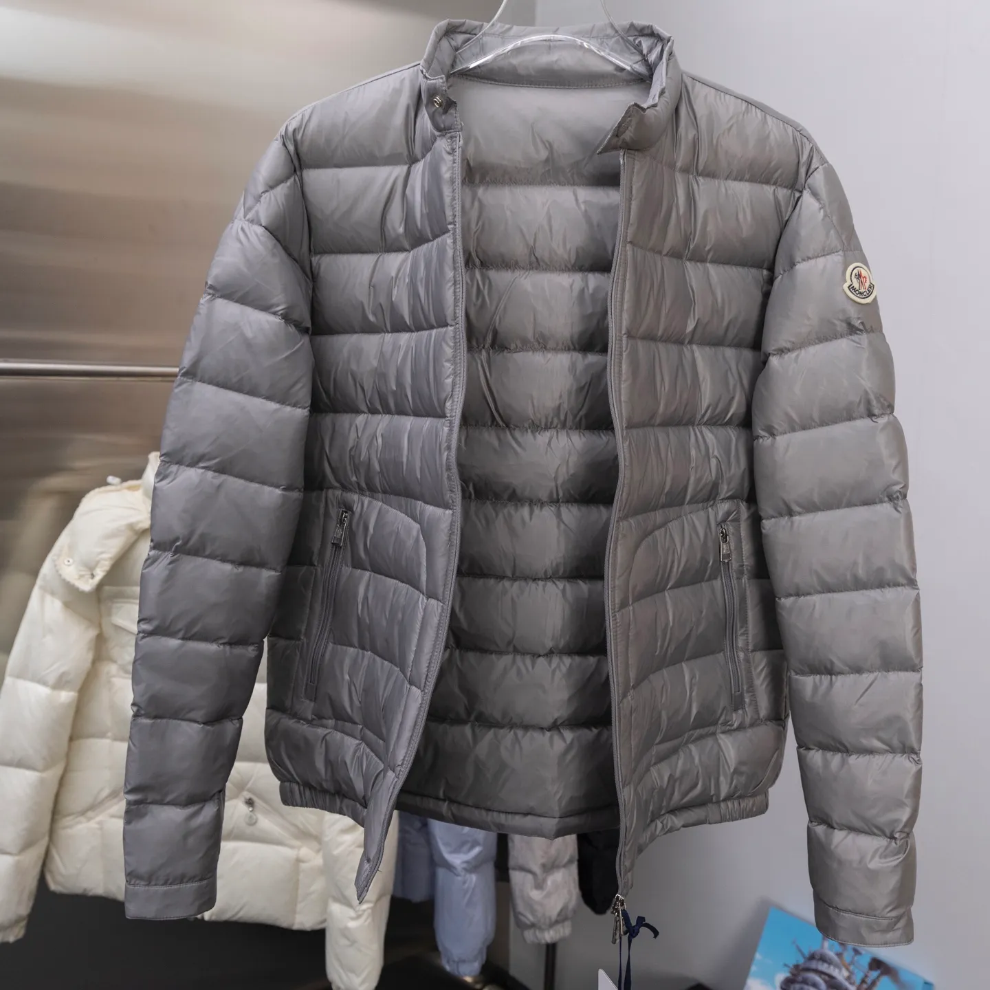 P620 2025 autumn and winter new style🆕Mon*ler Acorus men's foldable short down jacket, code number 12345, men's model, trading company channel goods. High-end tasting products. Top-notch Romanian products. Mon*ler Acorus men's fashionable and casual stand-up collar light down jacket jacket. Supplied to Japanese Toray company outdoor professional technical fabrics, stitching from Japan's top Fuji (FUJIX) Provided by KING) King Line, the interior is filled with Hungarian platinum-grade Hordobagy white goose down. The high-quality velvet extracted from the belly of the white goose has a diameter of 53MM. It has extremely high bulkiness and velvet content. It has excellent resilience, exceeds the European standard environmental protection level, has no odor, and has excellent temperature locking effect and warmth retention! High luxury fashion is combined with functional outdoor style. The sleeve arms retain the iconic brand wool badge body, focusing the brand's cultural essence and identity on it. It is fashionable and eye-catching!  The Acorus men's down jacket is a classic Moncler design item that embodies the brand's timeless aesthetics and sportswear essence. This short down jacket is made of Longue saison fabric, which combines lightweight texture with excellent thermal protection properties.  The craftsmanship details are exquisite and the accessories are all supplied by customers. It is a down jacket with strong wearability. It has a full upper body and a wide age range. It can be worn trendy or restrained and stable. It is very fashionable. It is highly recommended as a must-have tool to keep out the cold! Color: black gray