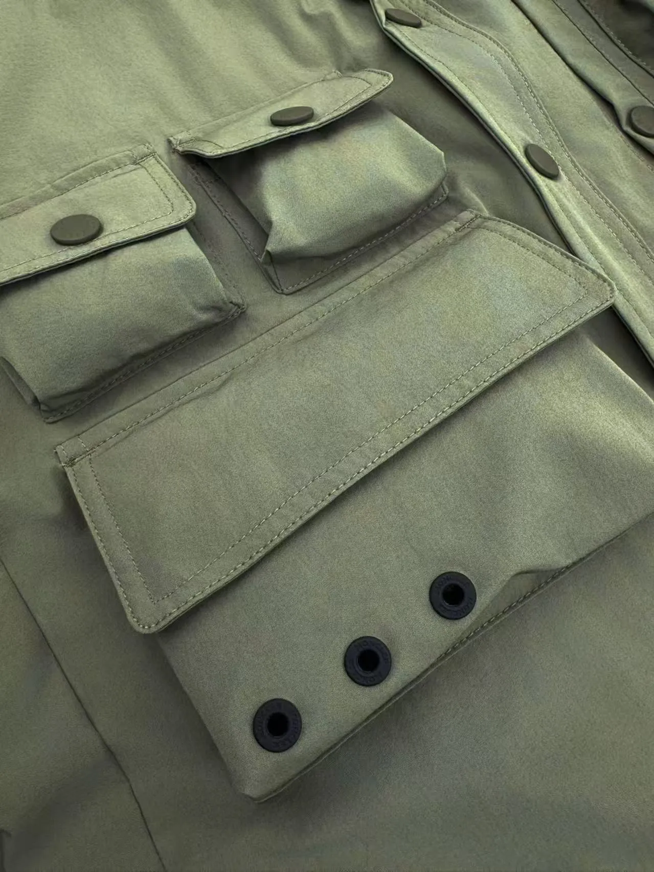 P560 Moncler Grenoble functional outdoor jacket Custom dyed double stretch mercerized poplin Custom dyed soft mesh pongee Excellent texture Comfortable and close to the skin Dark green inspired by plant texture The color is taken from sage leaves soaked in morning dew Precision narrative of functional pocket system Balance of function and aesthetics The iconic Moncler logo appears on the sleeves, fully recognizable The triangular logo of the same color is hidden in the fabric texture like a mark in the undercurrent of the deep sea, extremely invisible and yet obvious The detachable sleeve design allows for diversified outfits. You can switch styles at will. It is chic and free, showing nobility. It balances outdoor practicality and urban aesthetics and leads the fashion. Process 1: Adopt a three-in-one process. Prioritize and evenly coat the glue on the surface of the substrate that needs to be composited, and then dry and solidify it. Then laminate the substrate with the adhesive film and the non-woven fabric, then cool and solidify, and then composite it with the filter non-woven fabric. The workmanship is cumbersome and complex, time-consuming and labor-intensive. Process 2: Embossing composite technology uses computer scanning to ensure that the imprint size and shape are consistent with the original, and then uses special glue as an adhesive to combine and solidify to achieve complete dryness and the best bonding effect. Process 3: Use CNC laser burning and cutting. Based on the high-energy characteristics of the laser, the moving path of the laser beam is precisely controlled by the laser generator to achieve precise cutting of the shape of the piece. Process 4: Template machine bag opening. The preset template guides the position, shape and size of the bag opening. The accuracy ensures the quality of the bag opening effect. Process 5: Using infrared special machine buttoning, the position is more precise and strong. Accessories: Customized 1:1 Moncler snap button Customized 1:1 Moncler resin buckle Customized 1:1 Moncler logo seal Customized 1:1 Moncler logo armband Customized 1:1 Moncler zipper rope ring Customized 1:1 Moncler zipper pull Customized 1:1 Moncler trademark Version: Loose version Function: Detachable sleeve splicing Style can be switched at will Size: 1 2 3 4