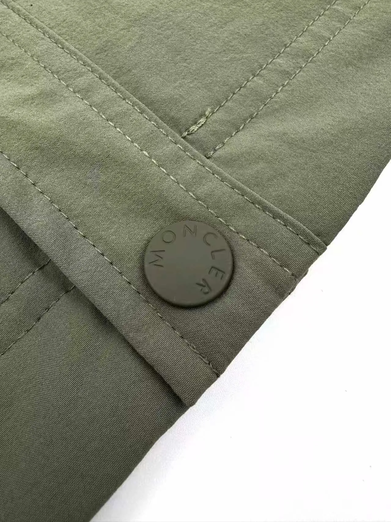 P560 Moncler Grenoble functional outdoor jacket Custom dyed double stretch mercerized poplin Custom dyed soft mesh pongee Excellent texture Comfortable and close to the skin Dark green inspired by plant texture The color is taken from sage leaves soaked in morning dew Precision narrative of functional pocket system Balance of function and aesthetics The iconic Moncler logo appears on the sleeves, fully recognizable The triangular logo of the same color is hidden in the fabric texture like a mark in the undercurrent of the deep sea, extremely invisible and yet obvious The detachable sleeve design allows for diversified outfits. You can switch styles at will. It is chic and free, showing nobility. It balances outdoor practicality and urban aesthetics and leads the fashion. Process 1: Adopt a three-in-one process. Prioritize and evenly coat the glue on the surface of the substrate that needs to be composited, and then dry and solidify it. Then laminate the substrate with the adhesive film and the non-woven fabric, then cool and solidify, and then composite it with the filter non-woven fabric. The workmanship is cumbersome and complex, time-consuming and labor-intensive. Process 2: Embossing composite technology uses computer scanning to ensure that the imprint size and shape are consistent with the original, and then uses special glue as an adhesive to combine and solidify to achieve complete dryness and the best bonding effect. Process 3: Use CNC laser burning and cutting. Based on the high-energy characteristics of the laser, the moving path of the laser beam is precisely controlled by the laser generator to achieve precise cutting of the shape of the piece. Process 4: Template machine bag opening. The preset template guides the position, shape and size of the bag opening. The accuracy ensures the quality of the bag opening effect. Process 5: Using infrared special machine buttoning, the position is more precise and strong. Accessories: Customized 1:1 Moncler snap button Customized 1:1 Moncler resin buckle Customized 1:1 Moncler logo seal Customized 1:1 Moncler logo armband Customized 1:1 Moncler zipper rope ring Customized 1:1 Moncler zipper pull Customized 1:1 Moncler trademark Version: Loose version Function: Detachable sleeve splicing Style can be switched at will Size: 1 2 3 4