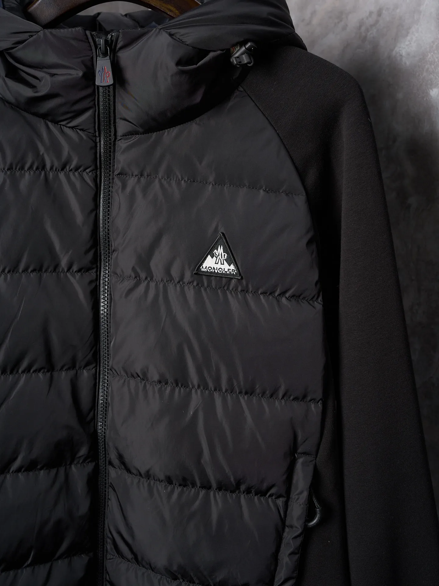 P780 Actual auction] Moncler/Mask Logo woven splicing down jacket [Ready stock] S M L XL custom matte lattice air shield velvet and 300D high-density calendered coating Using the new national standard 90 white duck down (welcome to test) Full of down content, full of warmth, light and fluffy, with a pure and extreme black tone, exuding an irresistible charm The Monlcer triangle logo is embellished on the chest, the power aesthetic of the minimalist logo The concentrated down filling in the front panel creates dynamic insulation for the core heat dissipation zone of the human body. The hooded down is a moving warm flow barrier for the head and neck, forming a thermal energy circulation system with the front panel. The elastic woven sleeves provide freedom of movement with a sense of compression, forming a relaxed and warm philosophy. Real high-end is to let function become the footnote of style. Computer mechanical down filling prioritizes the liner paper pattern to determine the down filling area according to the original three-dimensional effect. Determine the weight of down per square meter to calculate the amount of down filling for each piece. The computerized down filling machine uses a digital weighing unit to achieve stable measurement. 3D three-dimensional quilting technology uses the programming system of the CNC quilting machine to accurately separate the down in different areas to ensure that the fillings are evenly fixed after sewing and avoid agglomeration or shifting. The computerized template machine lines the lines. The computerized template machine lines the line process with extremely high neatness and smoothness. The craftsman accurately controls the size during the operation to ensure that each line meets the design requirements. The lines of the entire template are smooth and uniform. Neat and beautiful. Triple locking and five-thread dense stitching technology. Main seam locking + diagonal reinforcement + raw edge wrapping. Triple structure to form a three-dimensional protective net at the edge of the fabric to avoid stitch breakage.