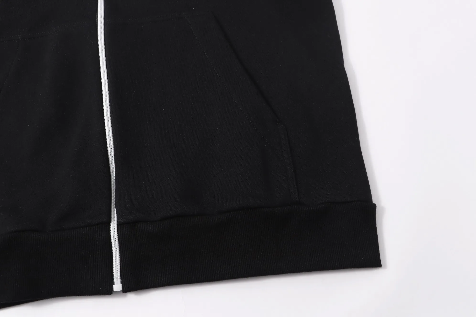 P340 💰 Moncler's new slogan printed zipper hooded jacket is made of lightweight turned velvet cotton fabric. High-density cotton fiber is used to achieve internal and external differentiation in a single layer of fabric. The outer plain weave is tight and wear-resistant, and the inner layer is formed into a short dense suede surface through a sanding process. The dense plain weave structure resists wind and splashes, the brushed suede surface is skin-friendly, and the short pile has been treated to eliminate static electricity to avoid sticking to the skin. A very small amount of grooved polyester moisture-conducting yarn is embedded in the cotton fiber, which quickly guides sweat from the inner suede surface to the outer layer for evaporation through the capillary effect, solving the problem of the suede being easily stuffy. By actively interfering with the shrinkage potential of cotton fibers, the fabric is able to transition from changeable to stable, improving dimensional stability while being less prone to deformation and wrinkles. High saturation is achieved on the center of the cap through glue printing. Size: xs-l