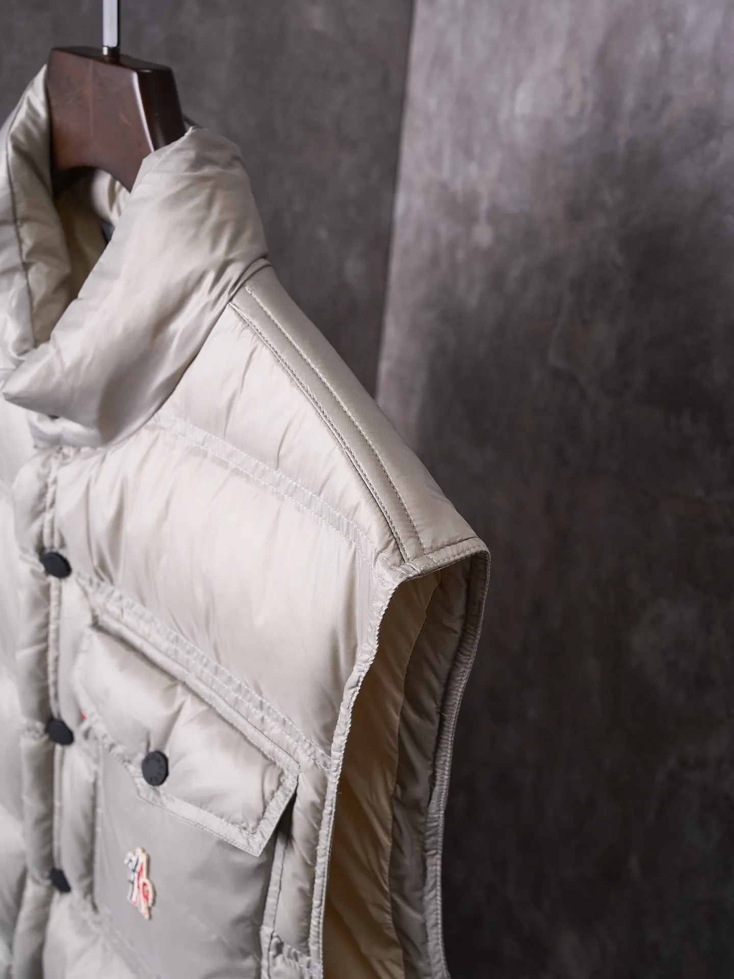 P680 Actual hanging auction] MONCLER/Mandow embroidered reflective logo stand-up collar down vest [Ready stock] 1 2 3 4 It is made of extremely fine nylon yarn and woven in a high-density way. The number of yarns per unit area is large, and the gaps between the yarns are very small, which can effectively block the penetration of cold wind. The fine weave keeps it lightweight and soft to the touch, physically restricting the lightweight down fibers from slipping through the gaps. Nylon fiber itself has good wear resistance and is not easy to snag, which significantly extends its service life and can easily cope with the needs of multiple scenarios.  The lining is made of high-density weaving of 100% polyester fiber, with a thickness of 0.08mm to avoid increasing the overall weight and making it smooth to wear. The high-density weaving structure forms a wind resistance layer to protect the thermal efficiency of the thermal layer from loss. It can withstand the expansion pressure of down and prevent deformation and damage after long-term use.  It uses 90 white duck down with a weight of 130g to ensure excellent thermal insulation performance. After strict screening and processing, the velvet is not easy to get drilled, ensuring durability.  Through the reflective cloth punching process, the logo is regularly arranged on the triangular reflective mark with dozens of small holes, which not only improves functionality but also enhances recognition and aesthetics.