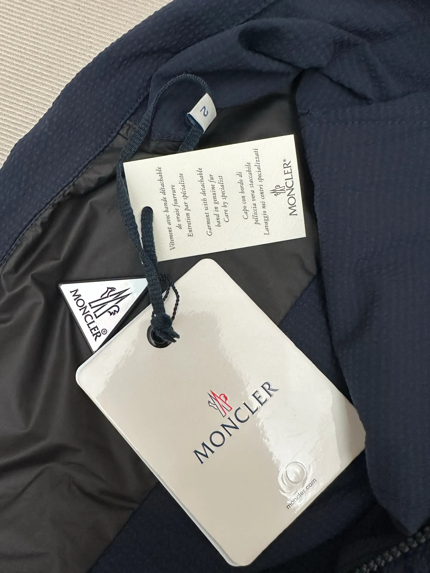 P440 MONCLER bubble wrinkle shirt jacket Fabric selection: Made of cotton blended woven fabric with 76% high cotton content + 24% polyester fiber. The high cotton content ensures that the fabric is soft, skin-friendly, and has good breathability. The addition of a small amount of polyester fiber balances the wrinkle resistance and elasticity of the overall fabric and greatly reduces its shrinkage. After preshrinking, dimensional changes during washing are negligible. The fusion of the two makes the fabric combine anti-wrinkle, quick-drying, easy care and other characteristics without losing the advantages of good wearing experience and strong breathability.  Bubble wrinkle technology: ground warp + bubble warp independent let-off. The bubble warp yarn feeding speed is about 20% higher than the ground warp yarn feeding speed. During weaving, the bubble warp is relaxed and accumulated, forming a naturally arched bubble unit. Through the alternating arrangement of yarns + floating length tissue changes, a clear grid frame is built between the bubble units, and finally the bubble three-dimensional effect and grid outline are locked through high-temperature heat setting.  Accessories: One-to-one customized zipper puller, one-to-one customized LOGO armband, one-to-one customized snap button SIZE: 1 2 3 4
