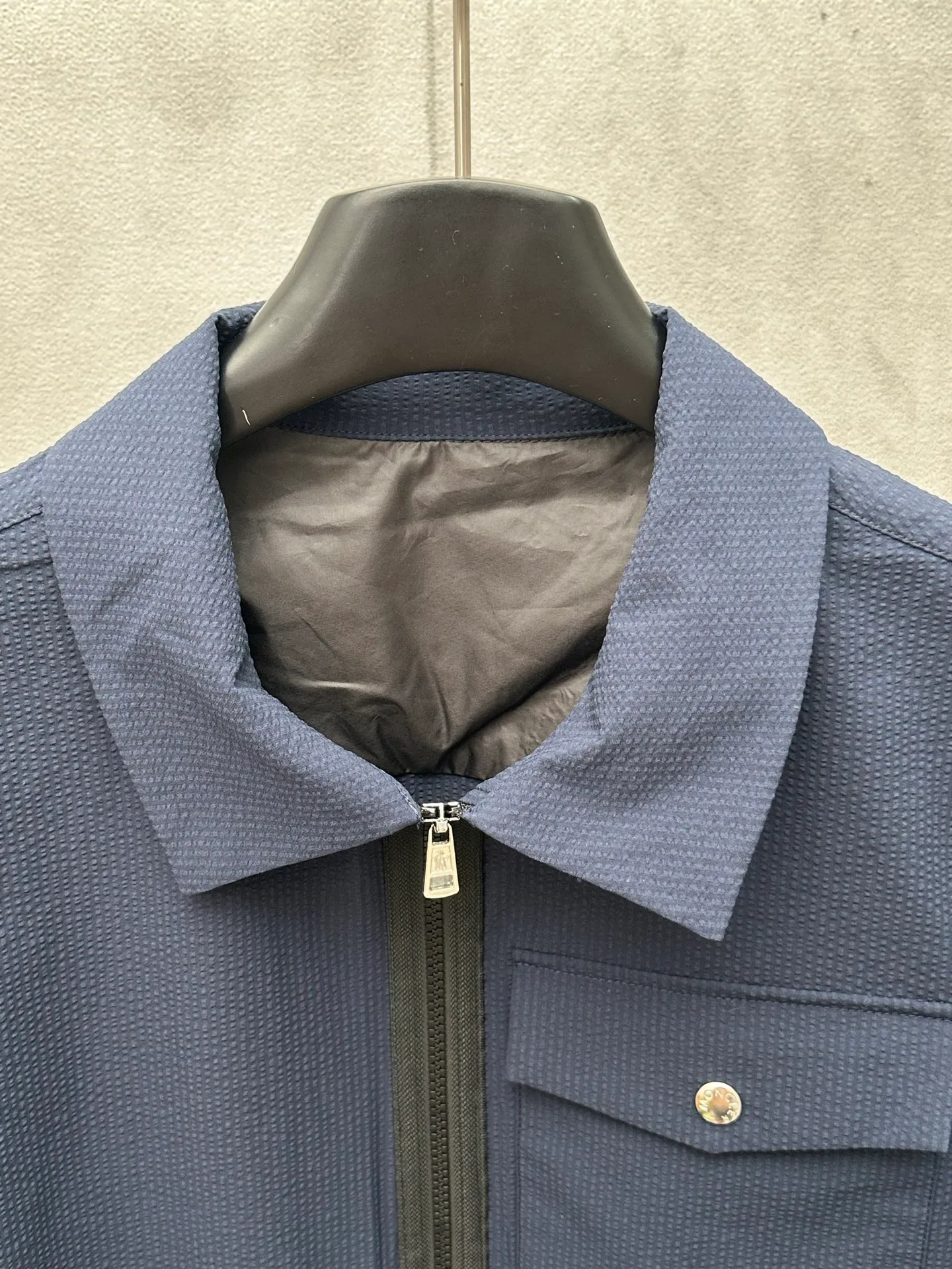 P440 MONCLER bubble wrinkle shirt jacket Fabric selection: Made of cotton blended woven fabric with 76% high cotton content + 24% polyester fiber. The high cotton content ensures that the fabric is soft, skin-friendly, and has good breathability. The addition of a small amount of polyester fiber balances the wrinkle resistance and elasticity of the overall fabric and greatly reduces its shrinkage. After preshrinking, dimensional changes during washing are negligible. The fusion of the two makes the fabric combine anti-wrinkle, quick-drying, easy care and other characteristics without losing the advantages of good wearing experience and strong breathability.  Bubble wrinkle technology: ground warp + bubble warp independent let-off. The bubble warp yarn feeding speed is about 20% higher than the ground warp yarn feeding speed. During weaving, the bubble warp is relaxed and accumulated, forming a naturally arched bubble unit. Through the alternating arrangement of yarns + floating length tissue changes, a clear grid frame is built between the bubble units, and finally the bubble three-dimensional effect and grid outline are locked through high-temperature heat setting.  Accessories: One-to-one customized zipper puller, one-to-one customized LOGO armband, one-to-one customized snap button SIZE: 1 2 3 4