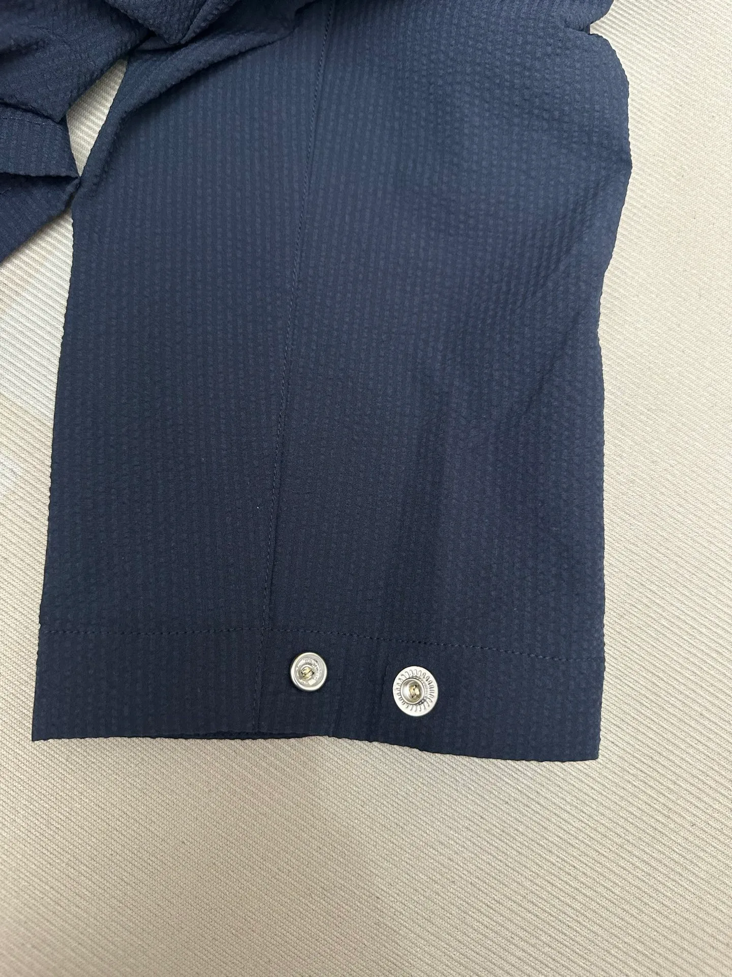 P440 MONCLER bubble wrinkle shirt jacket Fabric selection: Made of cotton blended woven fabric with 76% high cotton content + 24% polyester fiber. The high cotton content ensures that the fabric is soft, skin-friendly, and has good breathability. The addition of a small amount of polyester fiber balances the wrinkle resistance and elasticity of the overall fabric and greatly reduces its shrinkage. After preshrinking, dimensional changes during washing are negligible. The fusion of the two makes the fabric combine anti-wrinkle, quick-drying, easy care and other characteristics without losing the advantages of good wearing experience and strong breathability.  Bubble wrinkle technology: ground warp + bubble warp independent let-off. The bubble warp yarn feeding speed is about 20% higher than the ground warp yarn feeding speed. During weaving, the bubble warp is relaxed and accumulated, forming a naturally arched bubble unit. Through the alternating arrangement of yarns + floating length tissue changes, a clear grid frame is built between the bubble units, and finally the bubble three-dimensional effect and grid outline are locked through high-temperature heat setting.  Accessories: One-to-one customized zipper puller, one-to-one customized LOGO armband, one-to-one customized snap button SIZE: 1 2 3 4