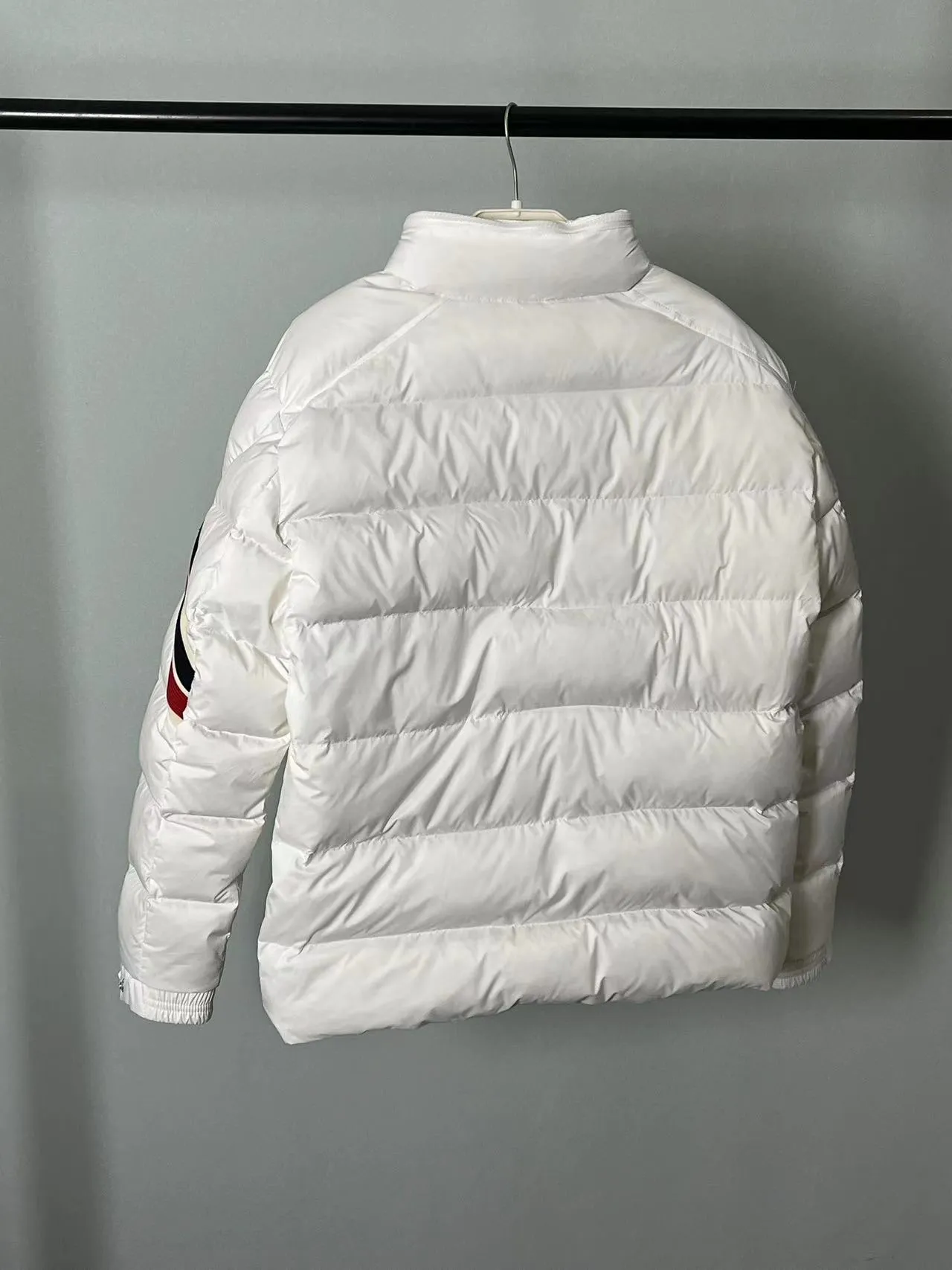 P920 🆕❤️2️⃣0️⃣2️⃣4️⃣Down⬆️Moncler Solayan men's tri-color trimmed short down jacket. Premium goose down filling. The finest, lightest and neatest fabric. Solayan men's short down jacket is decorated with seasonal iconic stripe details, blending sporty spirit and timeless style.  The Solayan down jacket is made of micro chic fabric and has a tough square shape design, highlighting Moncler's sporty spirit. This cropped down jacket features tricolor stripes on the sleeves, a seasonal take on the brand's signature. Comes with a practical pull-out hood. Details •Made from micro chic nylon fabric •Micro chic nylon lining •Down filled •Pull-out hood •Zip closure •Zip pockets •Adjustable cuffs •Elastic drawstring hem •Tri-color trim on sleeves Size: 1-5 Color: White Dark Brown Black