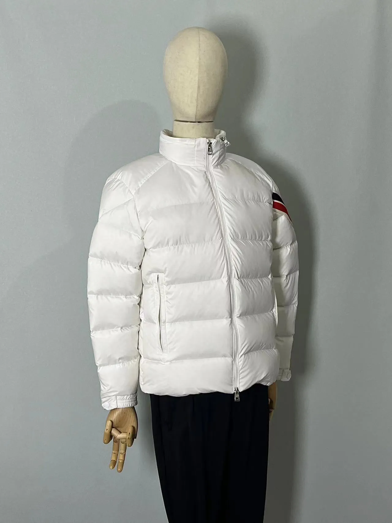 P920 🆕❤️2️⃣0️⃣2️⃣4️⃣Down⬆️Moncler Solayan men's tri-color trimmed short down jacket. Premium goose down filling. The finest, lightest and neatest fabric. Solayan men's short down jacket is decorated with seasonal iconic stripe details, blending sporty spirit and timeless style.  The Solayan down jacket is made of micro chic fabric and has a tough square shape design, highlighting Moncler's sporty spirit. This cropped down jacket features tricolor stripes on the sleeves, a seasonal take on the brand's signature. Comes with a practical pull-out hood. Details •Made from micro chic nylon fabric •Micro chic nylon lining •Down filled •Pull-out hood •Zip closure •Zip pockets •Adjustable cuffs •Elastic drawstring hem •Tri-color trim on sleeves Size: 1-5 Color: White Dark Brown Black
