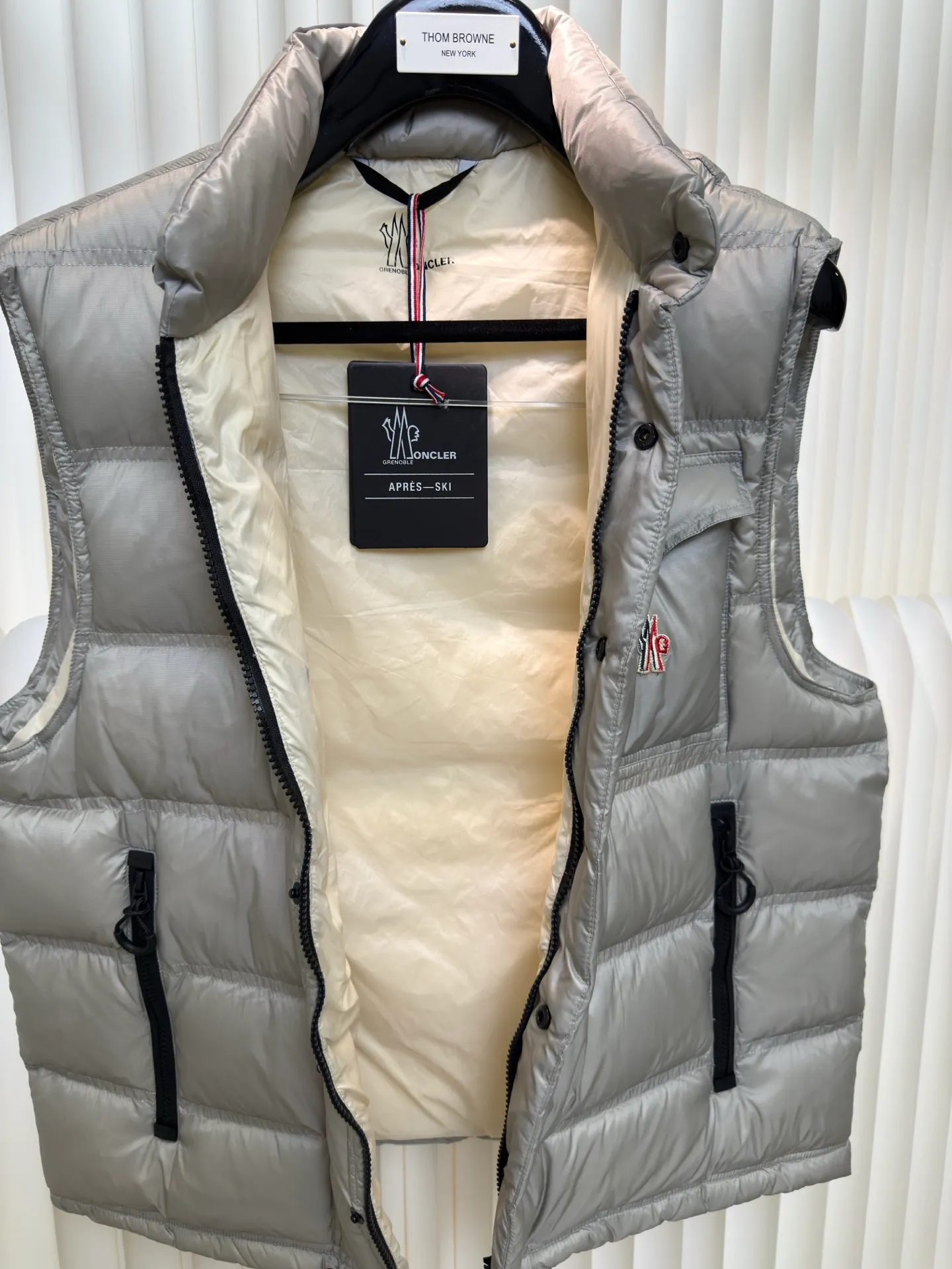 P700 MONCLER masked down vest with reflective markings is made of 90 white duck down with a weight of 130g to ensure excellent thermal insulation performance. After strict screening and processing, the velvet is not easy to get drilled, ensuring durability.  It is made of extremely fine nylon yarn and is woven in a high-density manner. The number of yarns per unit area is large, and the gaps between the yarns are very small, which can effectively block the penetration of cold wind. The fine weave keeps it lightweight and soft to the touch, physically restricting the lightweight down fibers from slipping through the gaps. Nylon fiber itself has good wear resistance and is not easy to snag, which significantly extends its service life and can easily cope with the needs of multiple scenarios.  The lining is made of high-density weaving of 100% polyester fiber, with a thickness of 0.08mm to avoid increasing the overall weight and making it smooth to wear. The high-density weaving structure forms a wind resistance layer to protect the thermal efficiency of the thermal layer from loss. It can withstand the expansion pressure of down and prevent deformation and damage after long-term use.  Through the reflective cloth punching process, the logo is regularly arranged on the triangular reflective mark with dozens of small holes, which not only improves functionality but also enhances recognition and aesthetics. Size 1 2 3 4