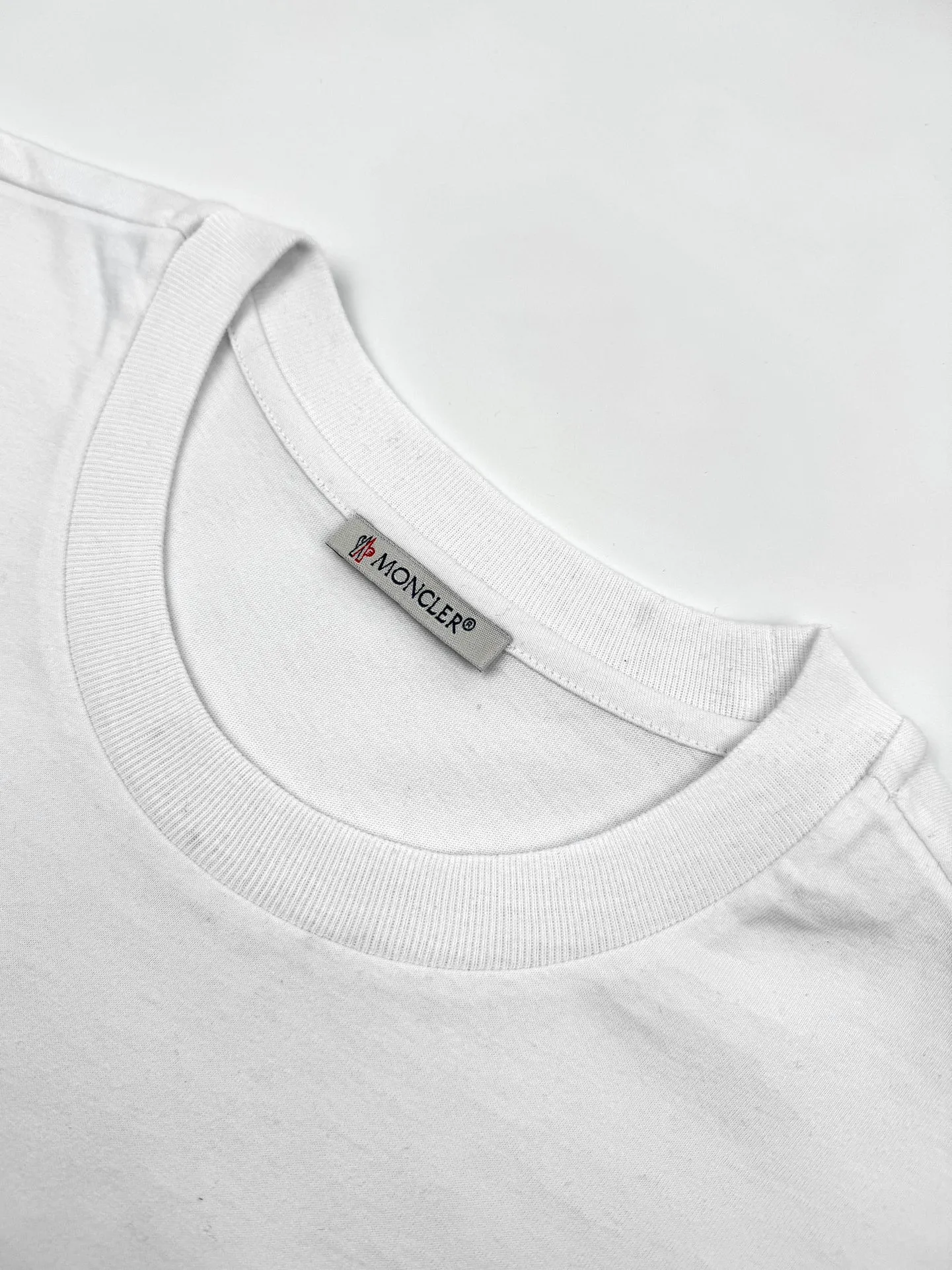 P180 Moncler logo short-sleeve, custom Yunshu velvet cotton plain weave, soft and delicate, comfortable and close to the skin, the iconic Moncler logo is embellished on the chest, like the soul mark of the artist, full of recognition, with porcelain white as the main color, exuding a soft and pure light, a double feast for the eyes and the soul. Needless to say, the end of the outfit is minimalism. Process 1: Computer pattern sewing machine process. Input the required pattern through computer software. High-precision positioning system ensures the accurate position of the pattern on the fabric. It has an automatic sewing function and can automatically complete the sewing process. Process 2: The fabrics are washed and have a better hand feel. Not easy to deform, not easy to shrink, not easy to fade, and maintain long-term beauty. Accessories: Customized 1:1 Moncler embroidery logo Customized 1:1 Moncler trademark Version: Loose version Size: S M L XL Style number: 25110